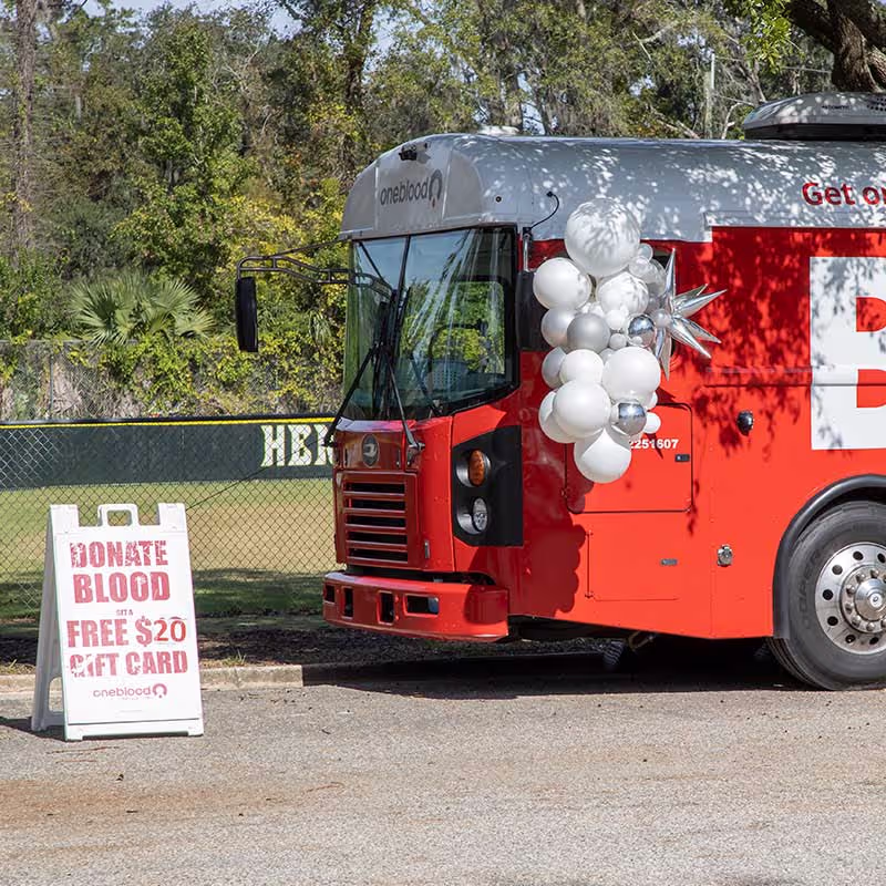 a red blood drive truck with a donate sign