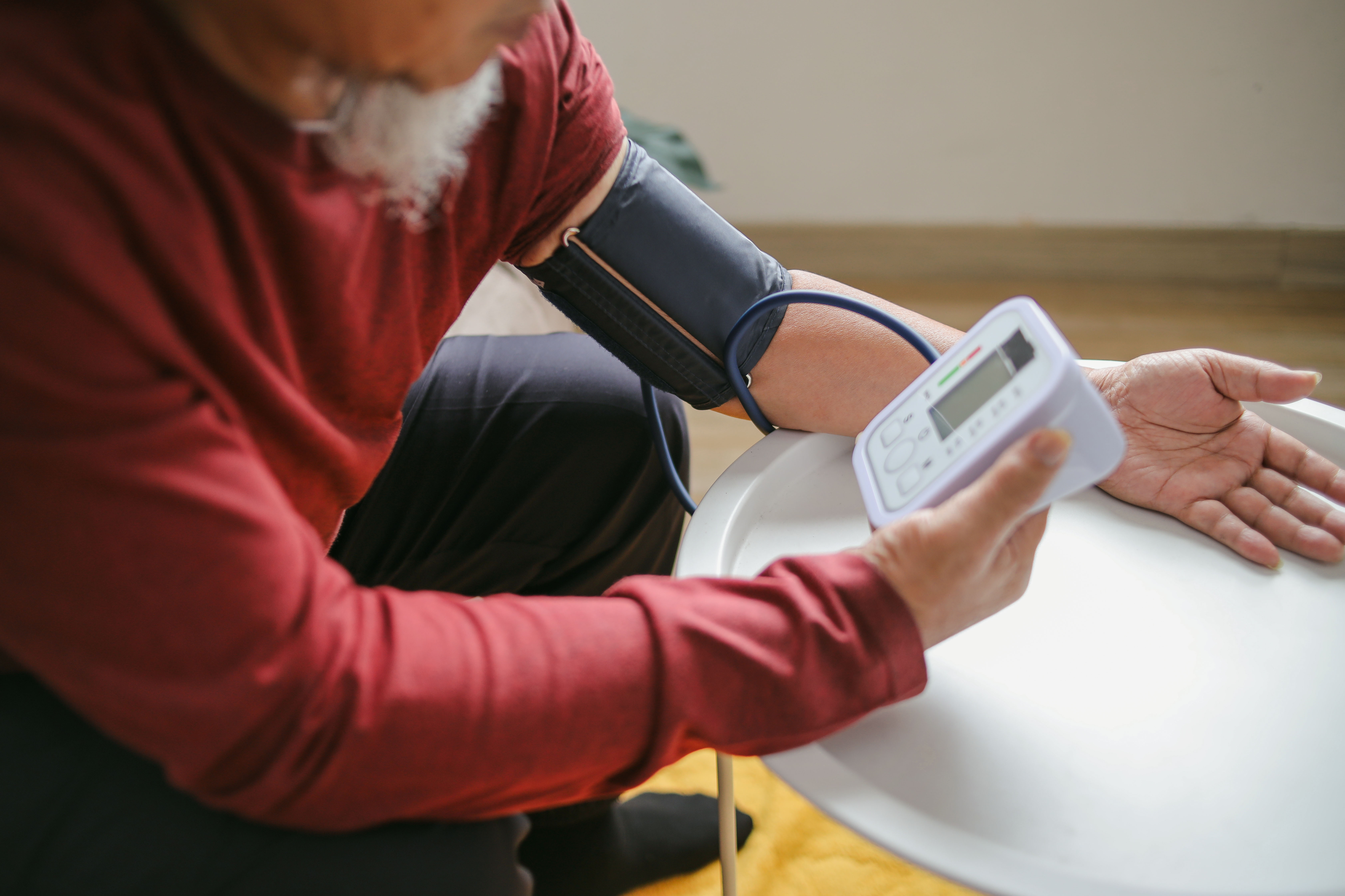 senior man checking blood pressure at home