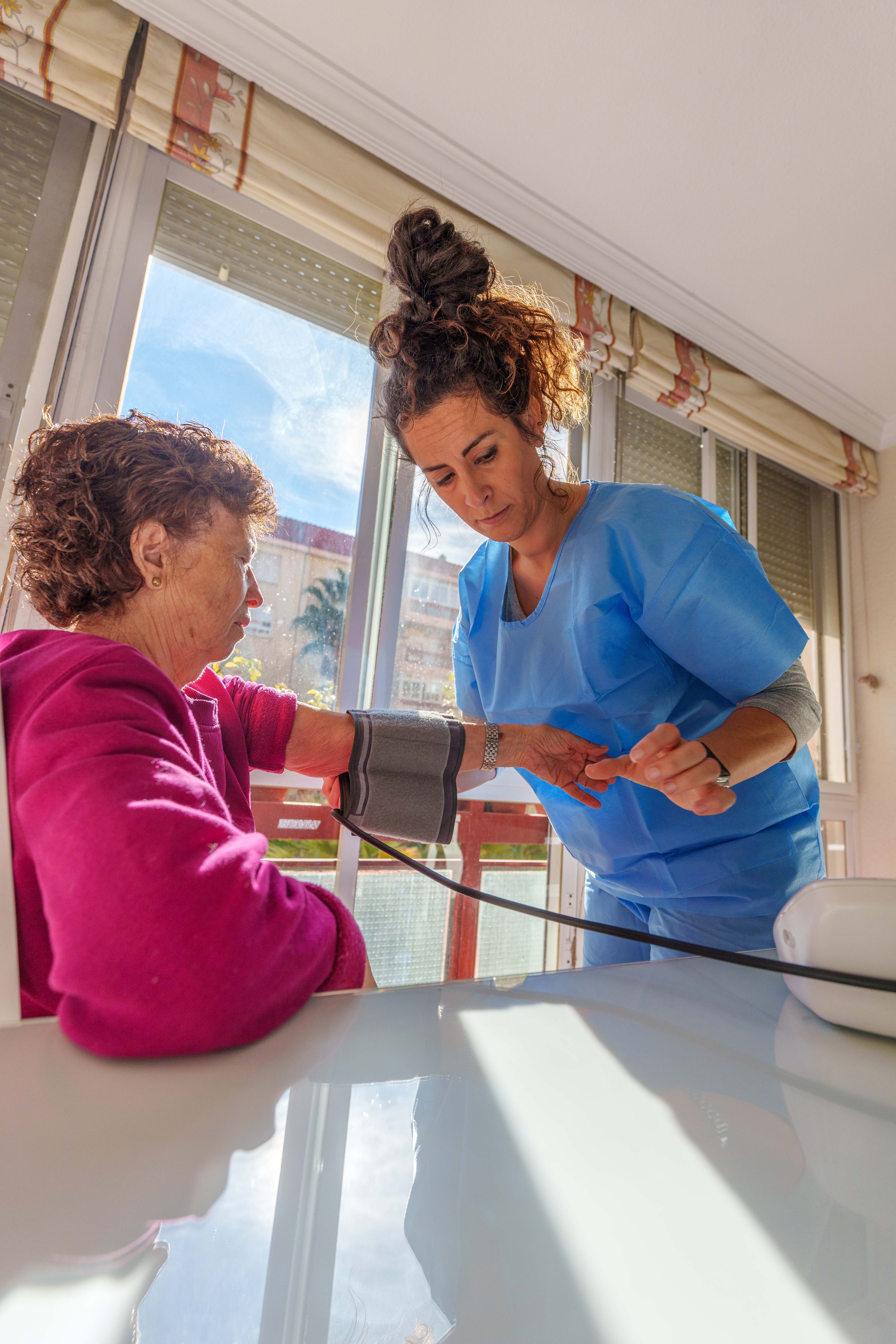 young nurse measuring blood pressure