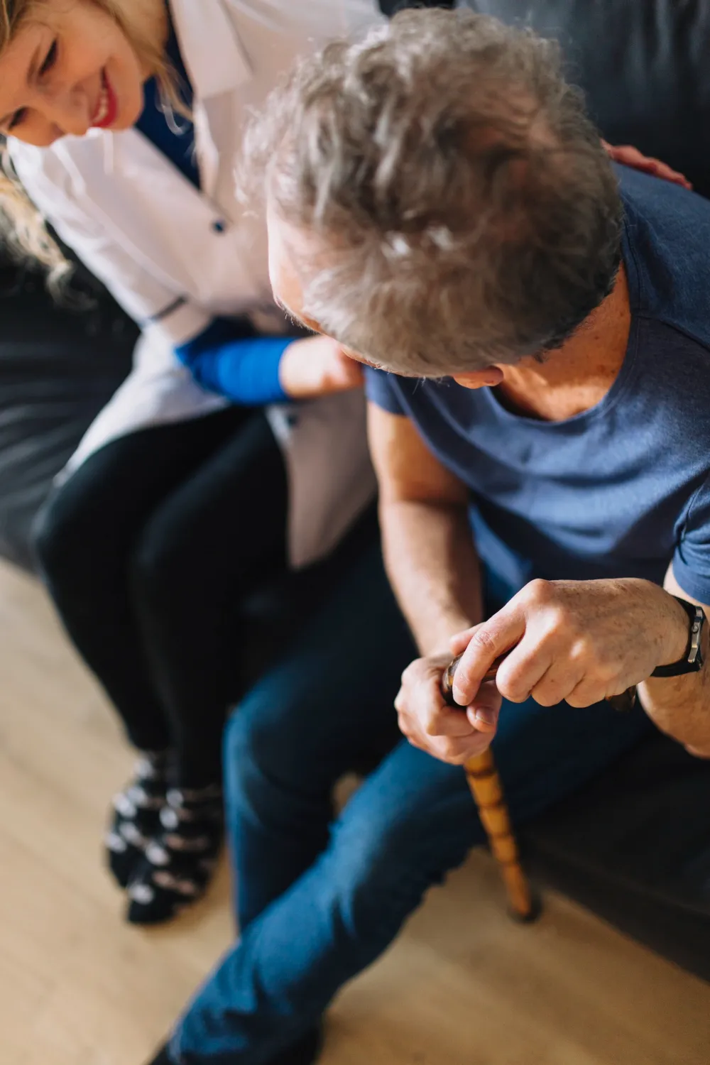 Caregiver comforting elderly patient in dementia care