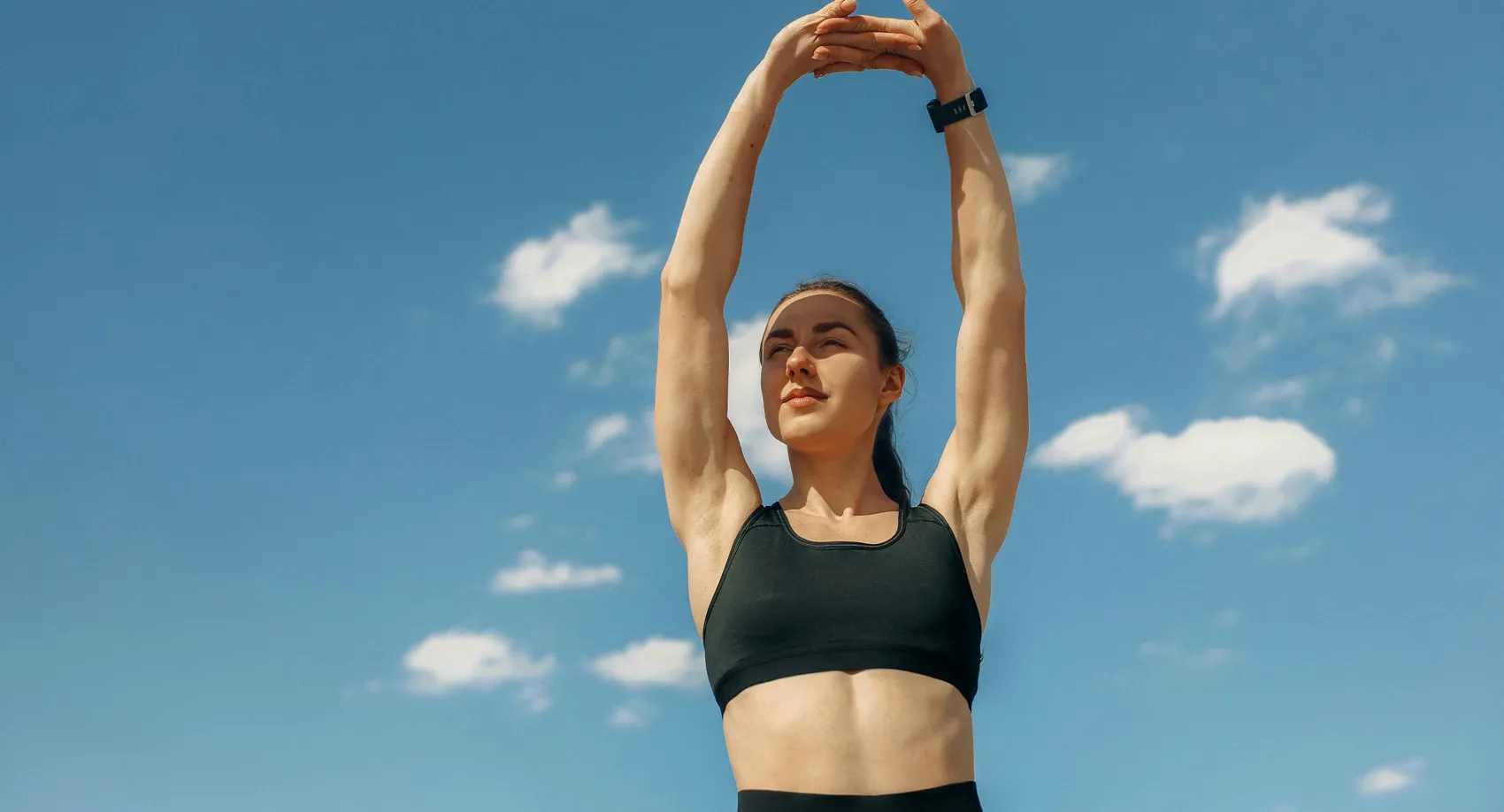 An athletic woman stretches outside, enjoying optimal health after seeing the best pain management doctor in Los Angeles