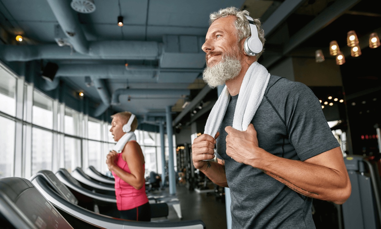 Active older man exercising on a treadmill at a modern gym, representing optimal men’s health and guidance from the best men’s health doctor in Los Angeles.