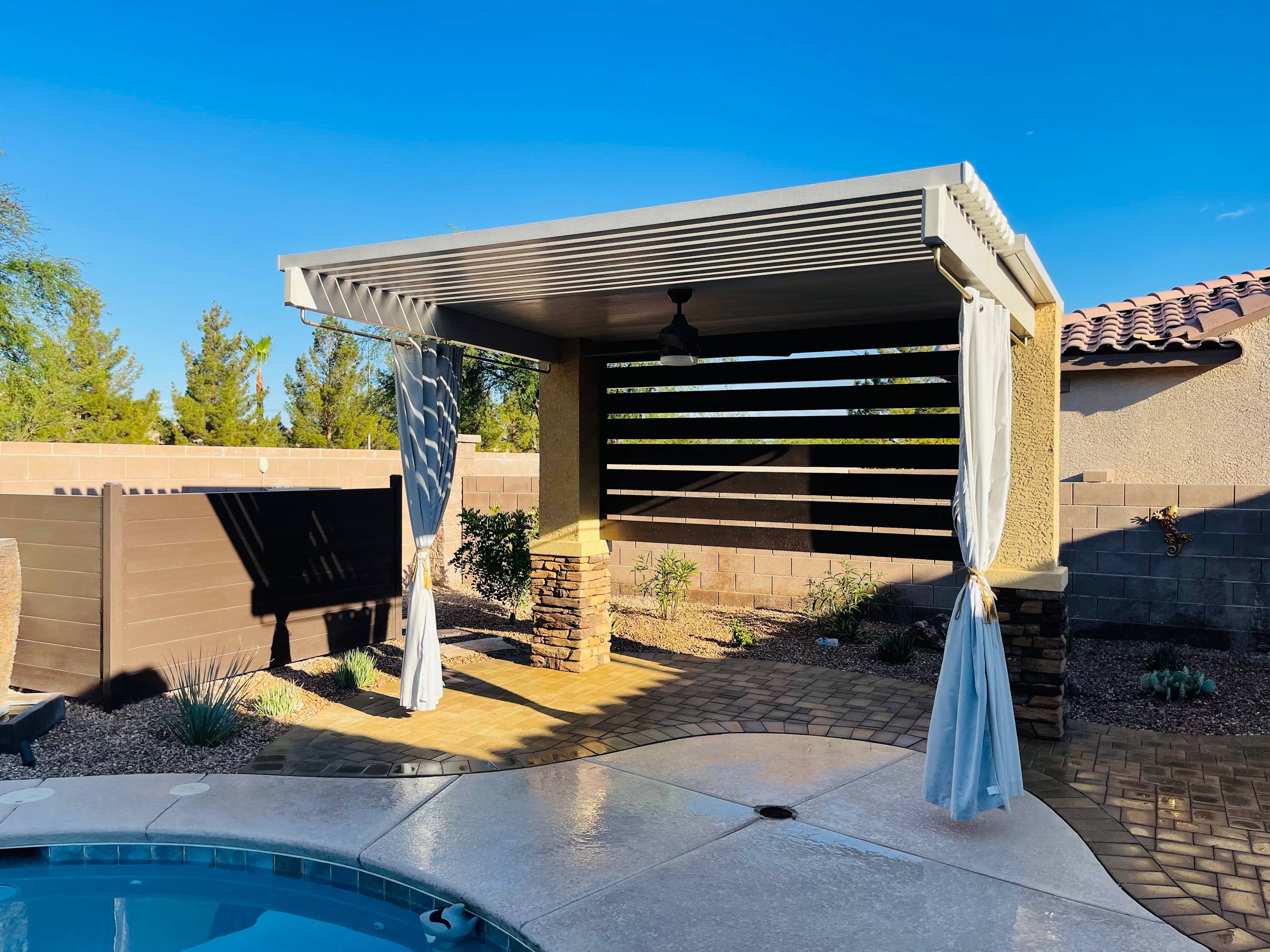 Charming garden area with a wooden gazebo, stone waterfall feature, and lush surrounding greenery