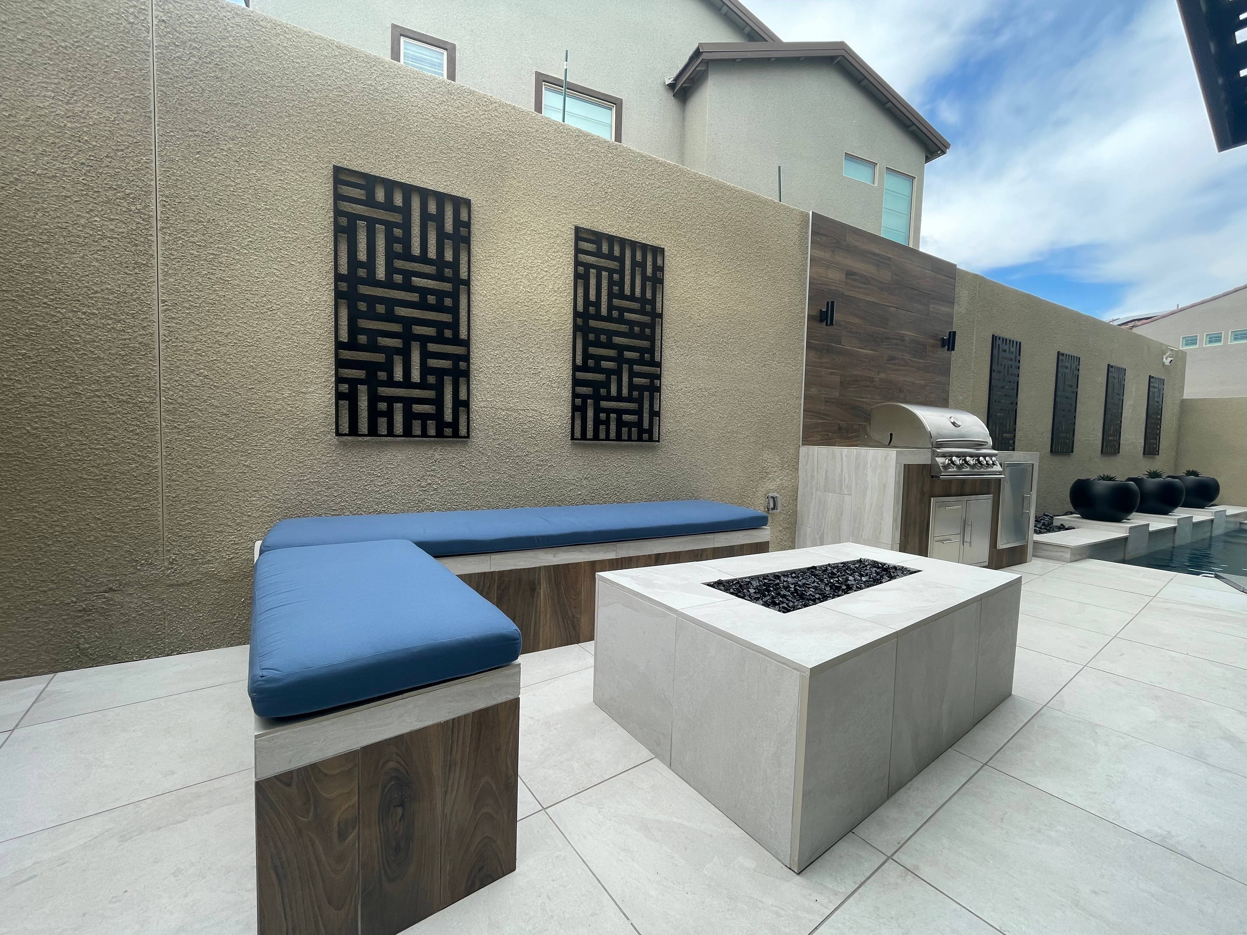 Modern outdoor kitchen and bar area with granite countertops and stainless steel appliances