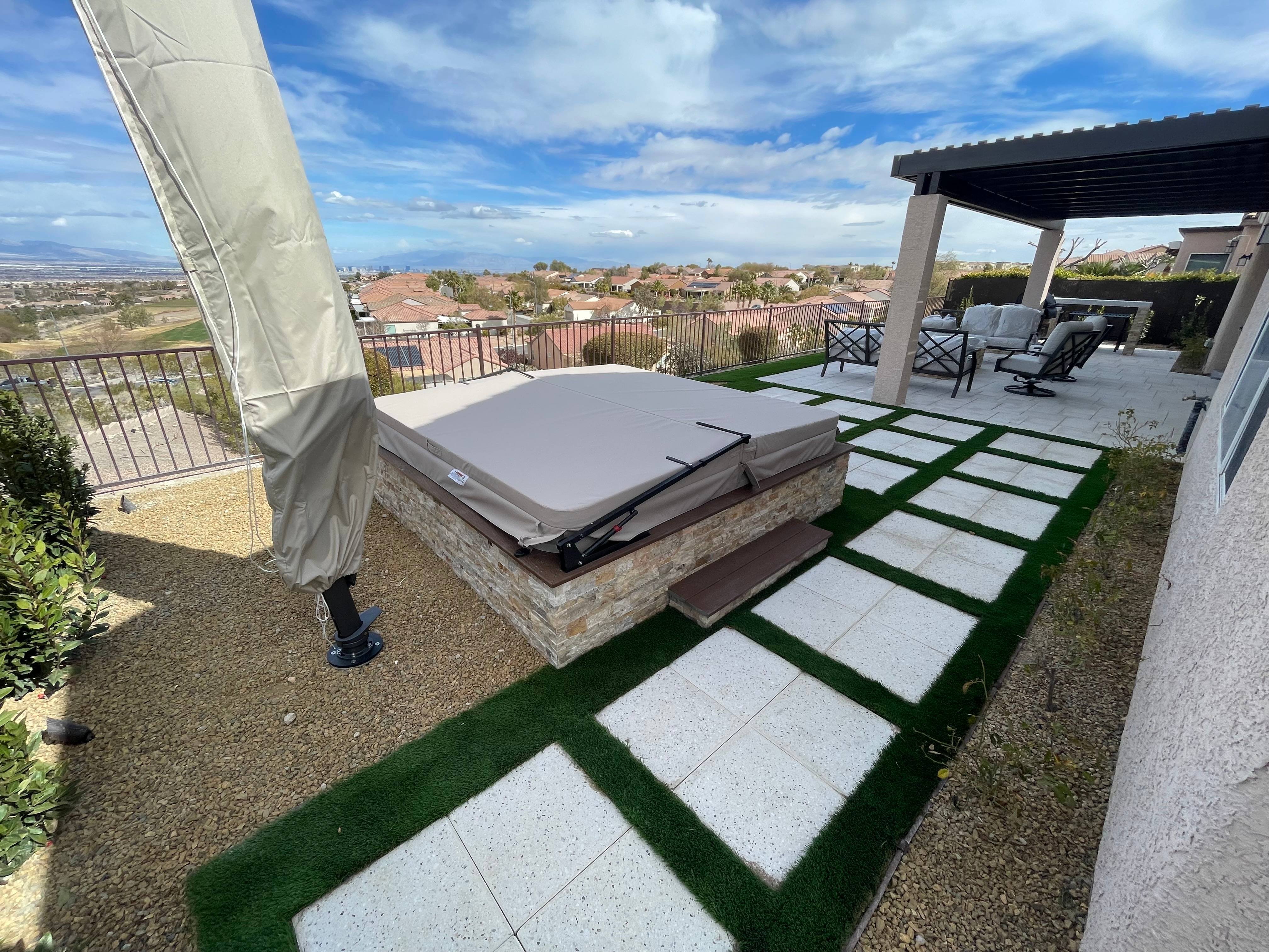 Spacious outdoor patio with custom pergola, dining area, and decorative stone flooring