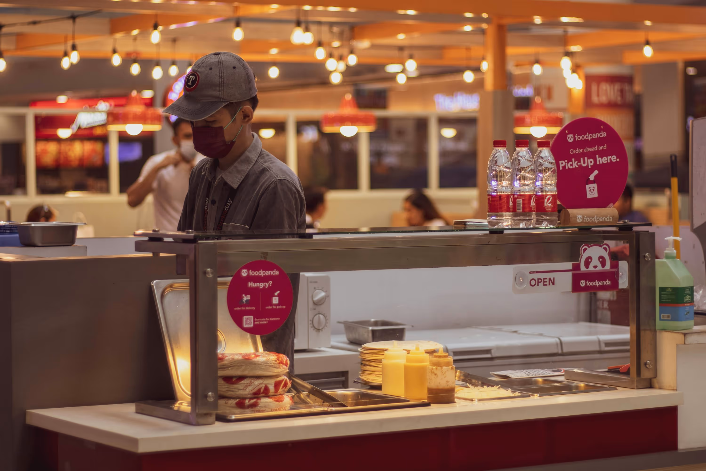 a man standing behind a counter in a fast food restaurant