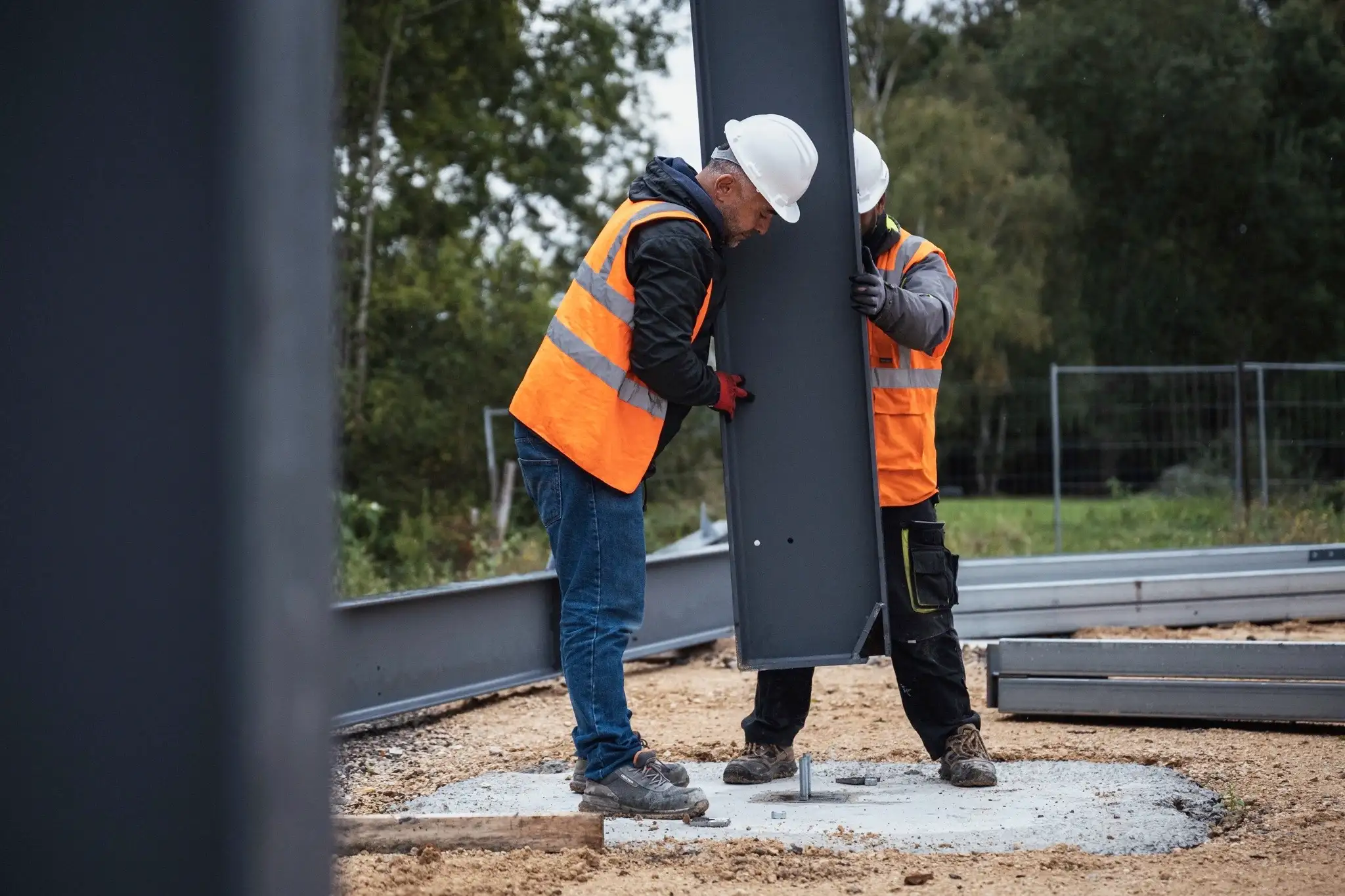 monteurs installant les pieds d'une structure métallique solaire