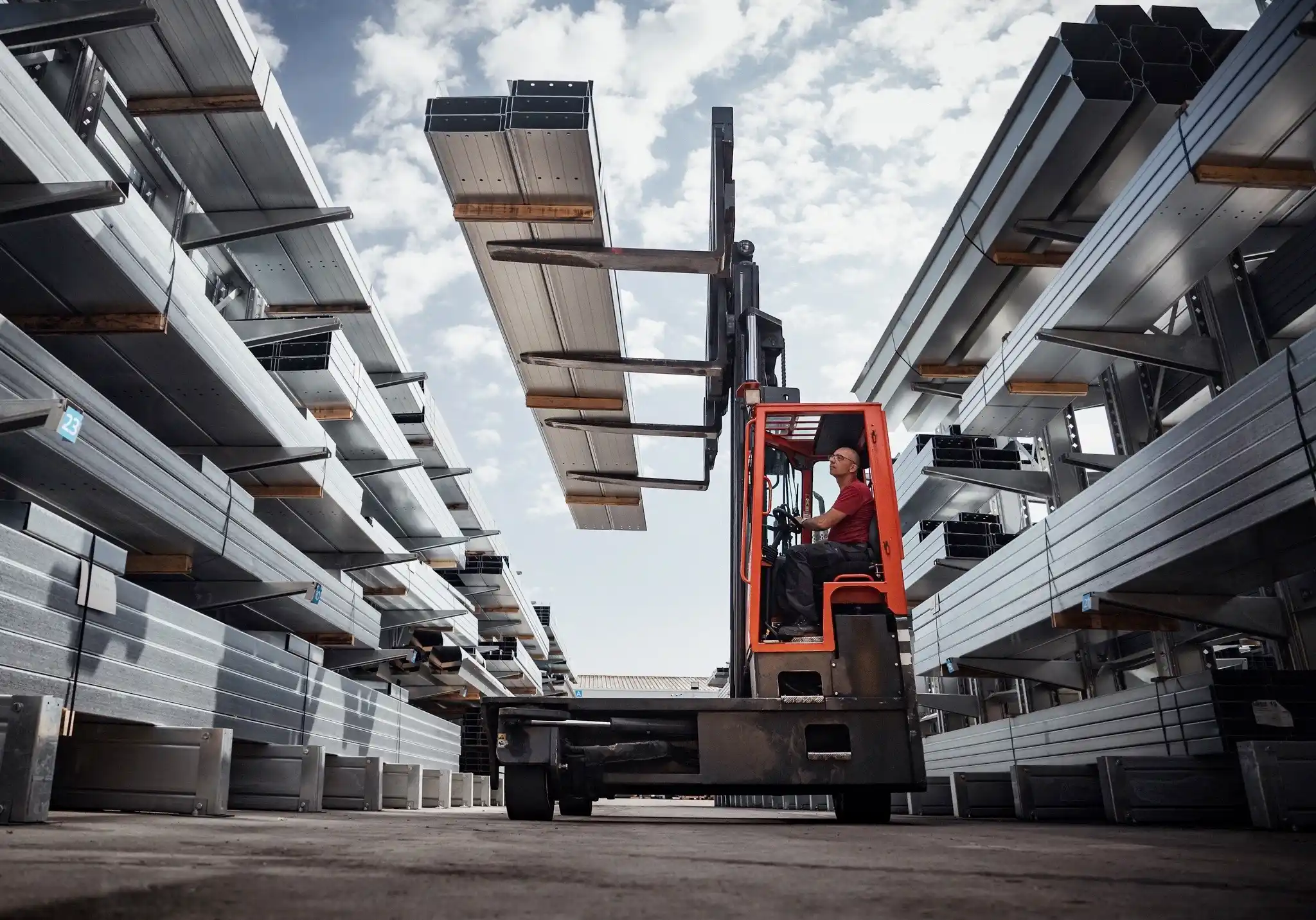 cariste déplaçant des éléments de charpente métallique