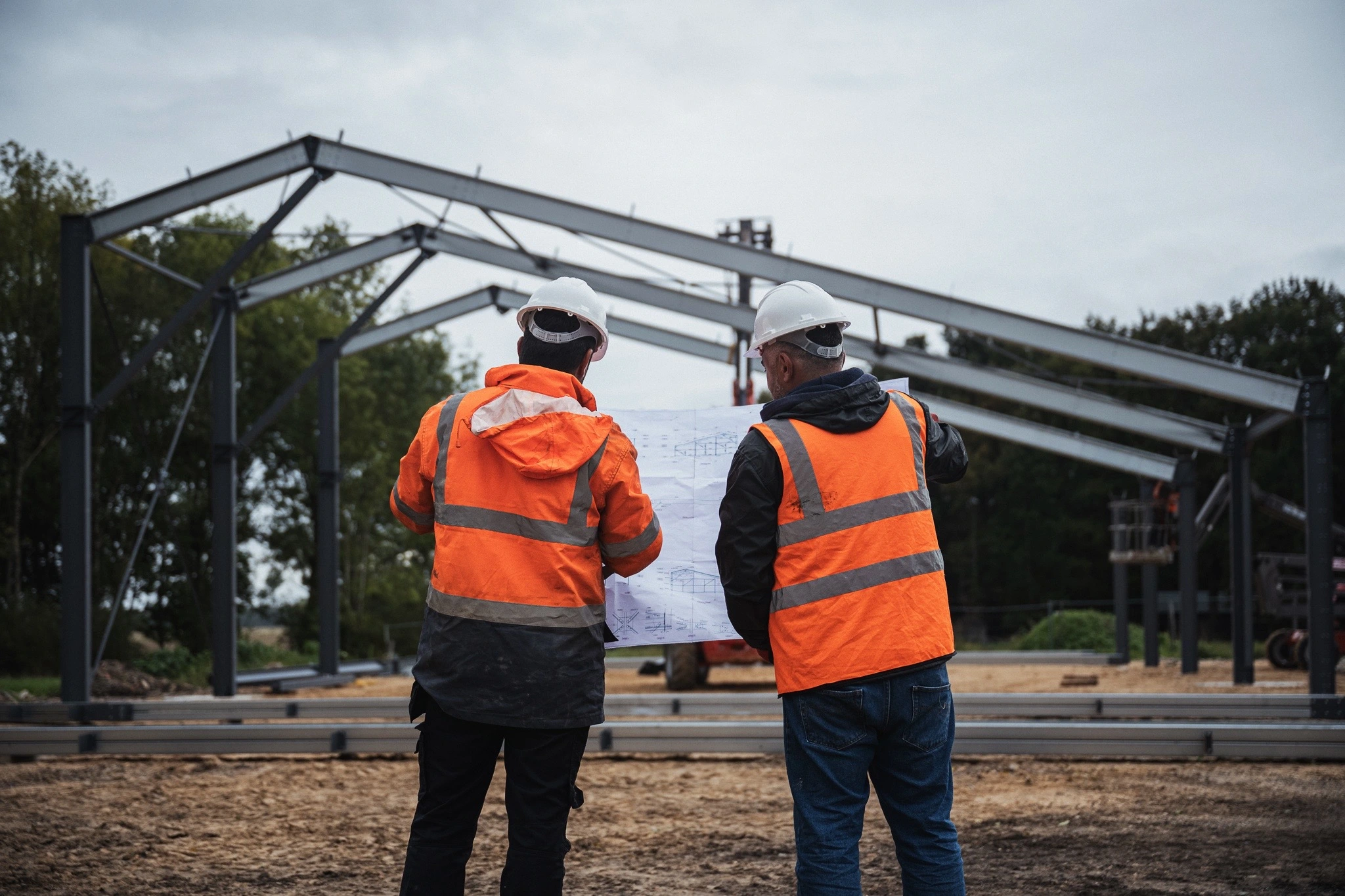 chef de chantier étudiant les plans d'un hangar photovoltaïque