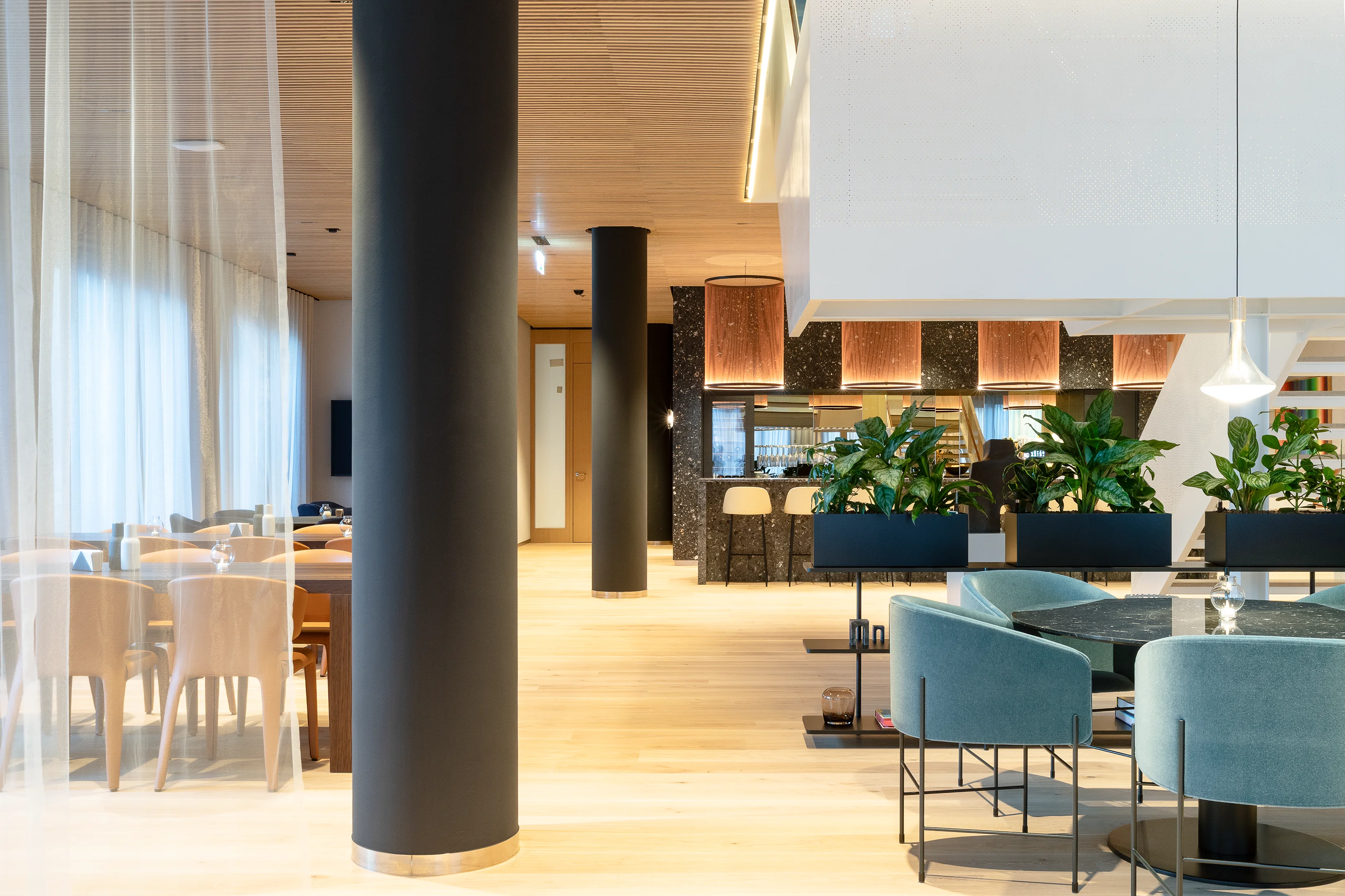 ChatGPT:

A stylish café-style office area with warm lighting, wooden furniture, and green plants.