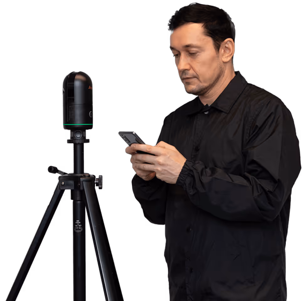 A digital surveyor, holding a phone using our capture app, next to a Leica Geosystems BLK360 LiDAR scanning device