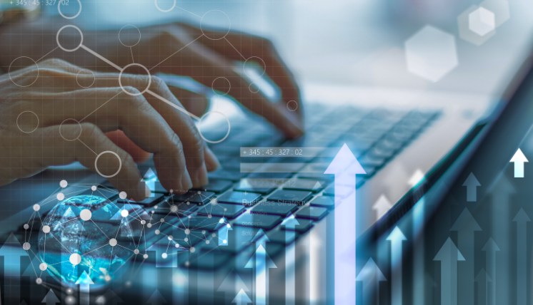 Hands typing on a laptop keyboard with abstract technology graphics overlayed, including network nodes, arrows pointing upward, and data visuals representing digital growth and technical program management concepts.