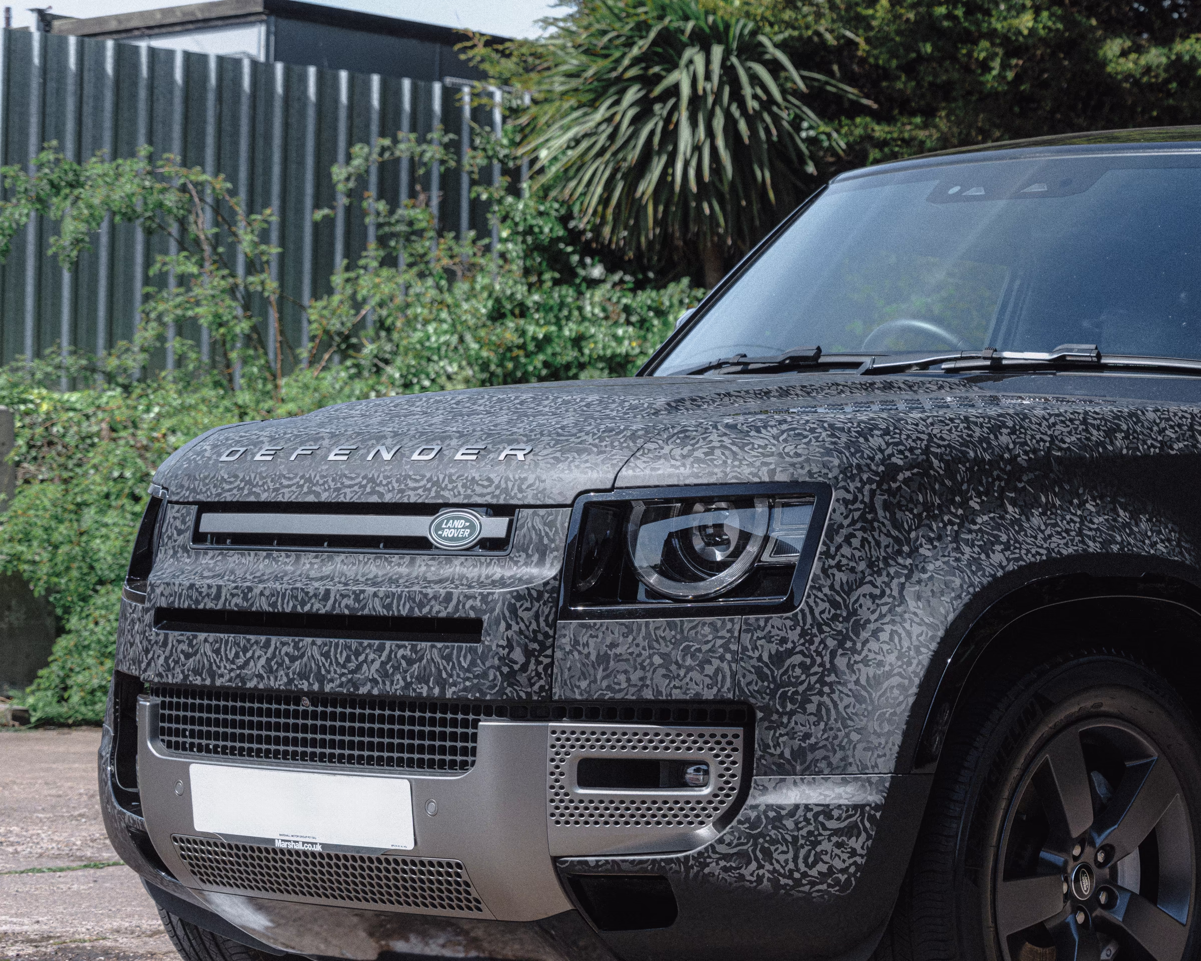 The front bumper of a Land Rover Defender, with a camo wrap by WCC.