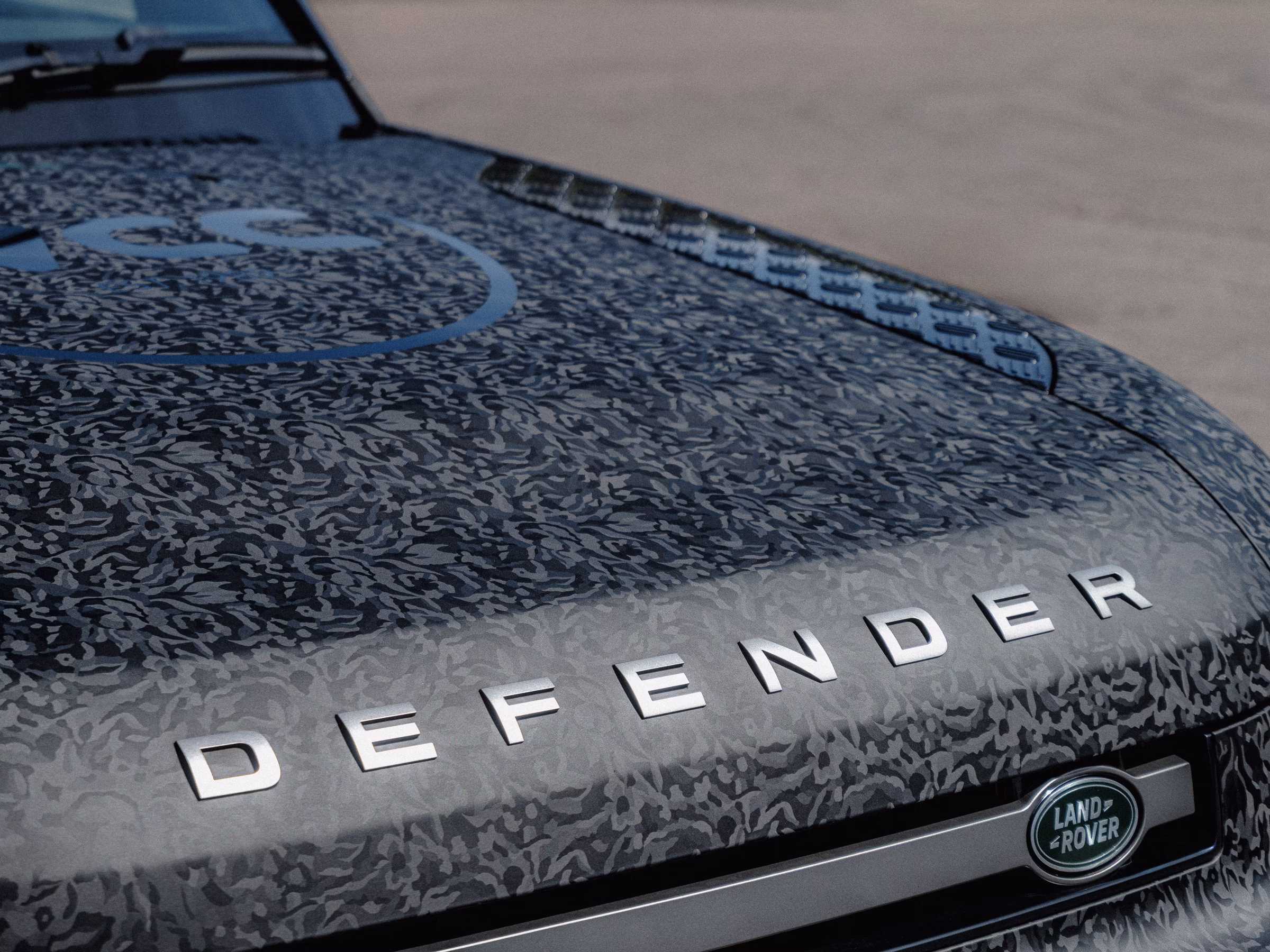 A black camo wrapped Defender bonnet.