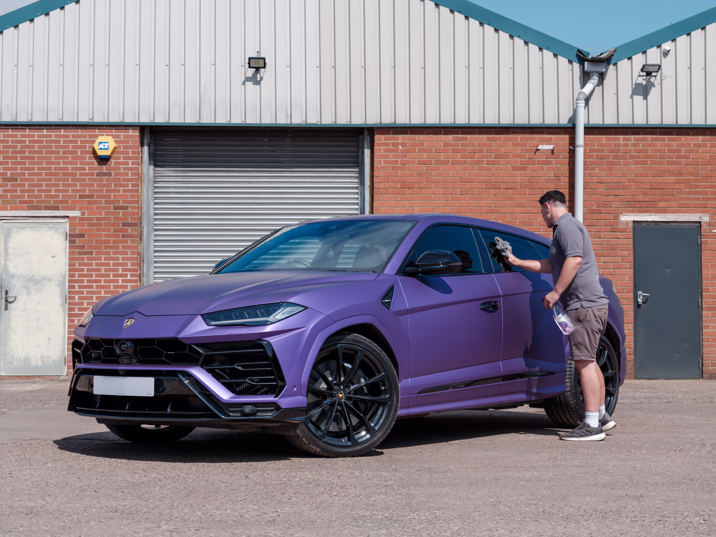 a WCC worker cleaning a newly wrapped Lamborghini Urus.