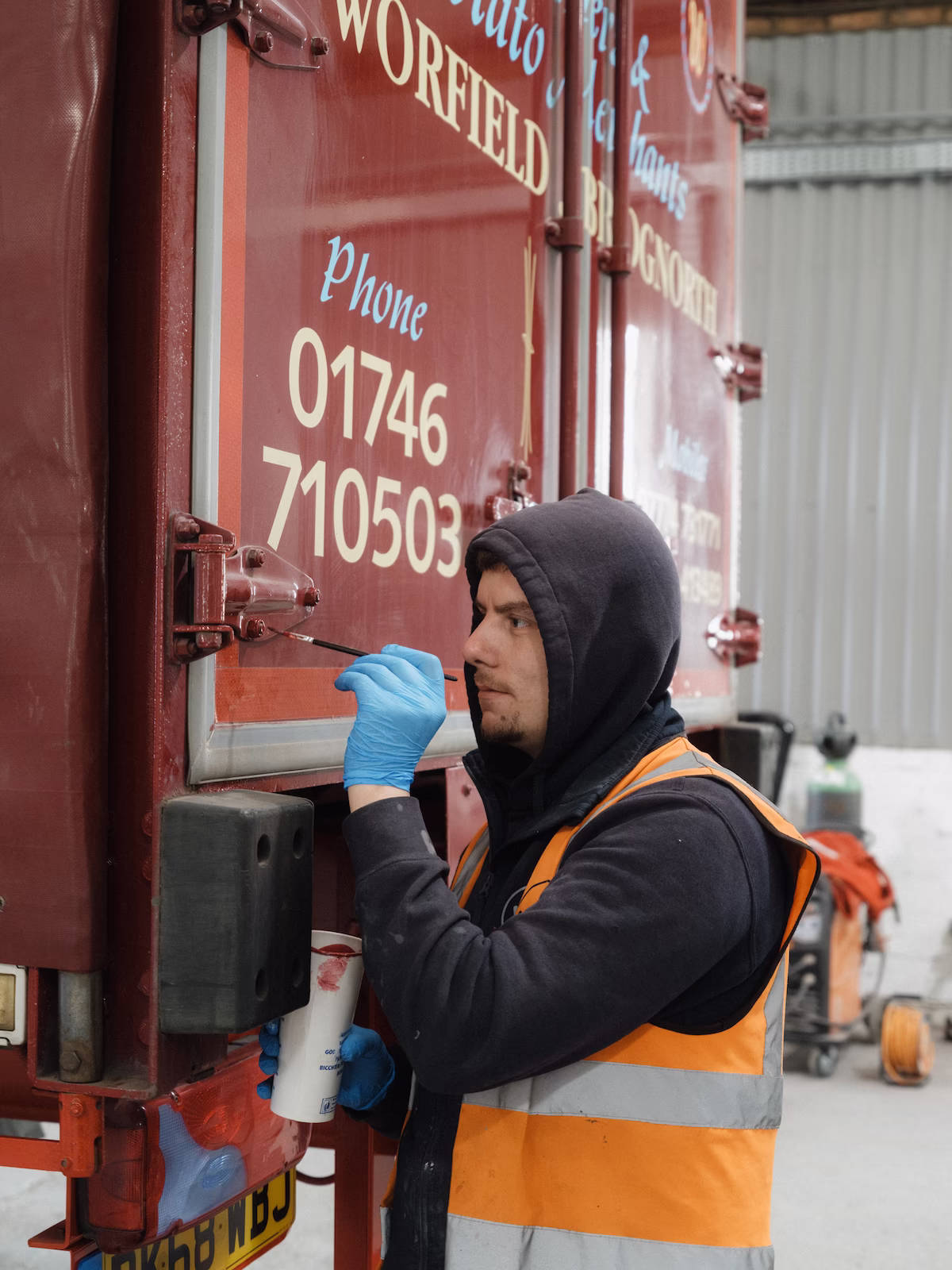 Detail of final touch-up paint being applied to hinges on T L Walker & Co vehicle.