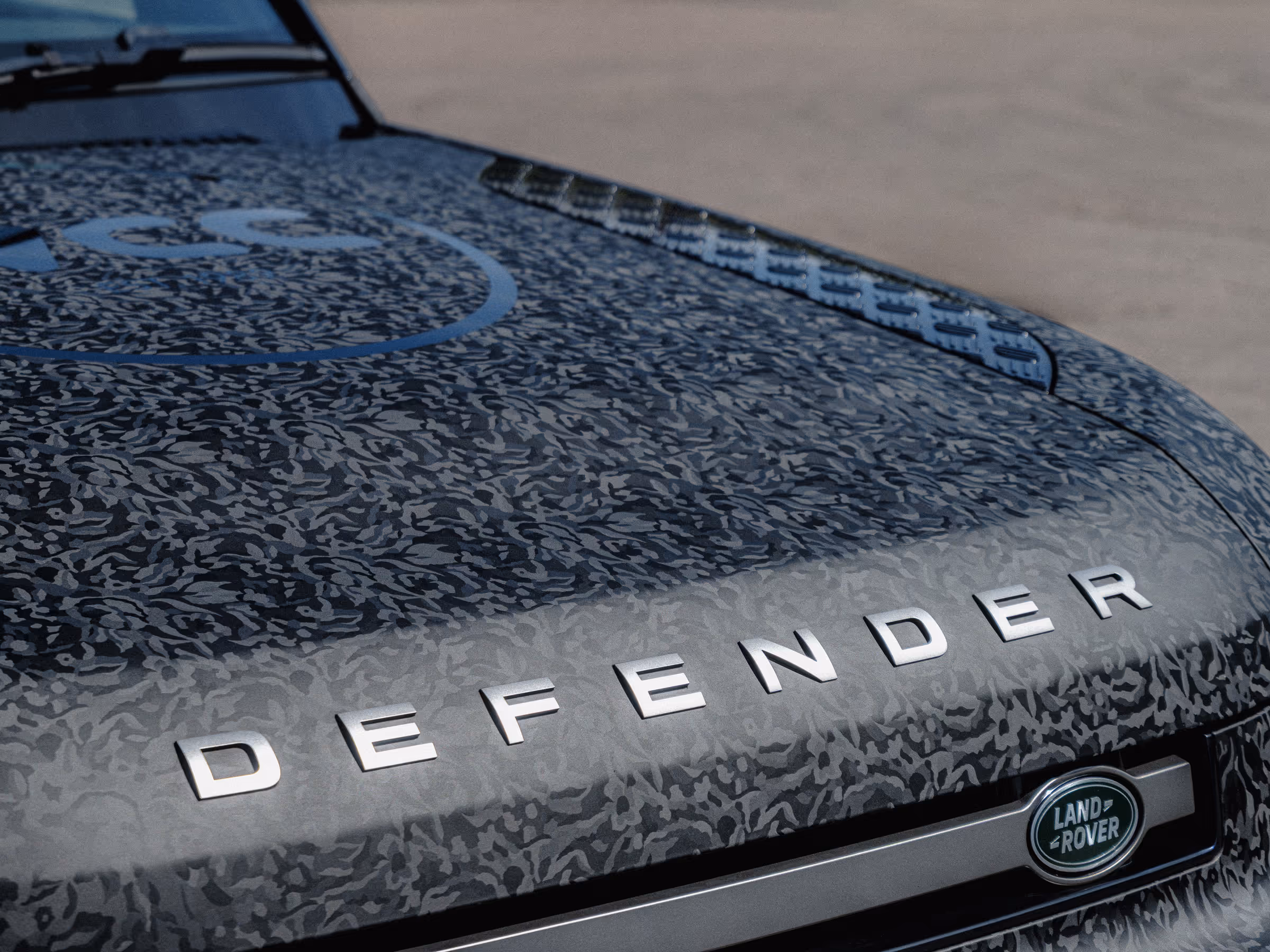 A Land Rover Defender 90 hood wrapped in a tactical black camo.