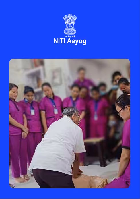 Man demonstrating CPR on a mannequin to a group of women in purple uniforms indoors.