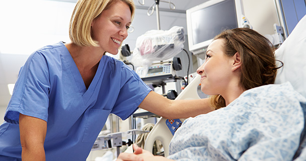 Mature female doctor discussing medical report with nurses in hospital hallway