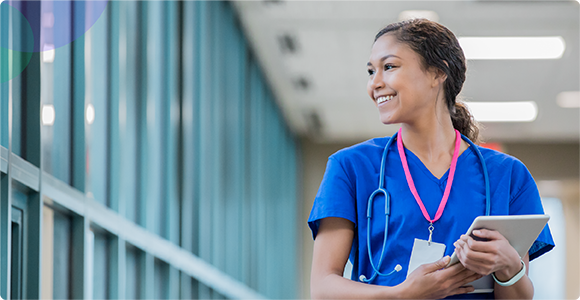 Mature female doctor discussing medical report with nurses in hospital hallway