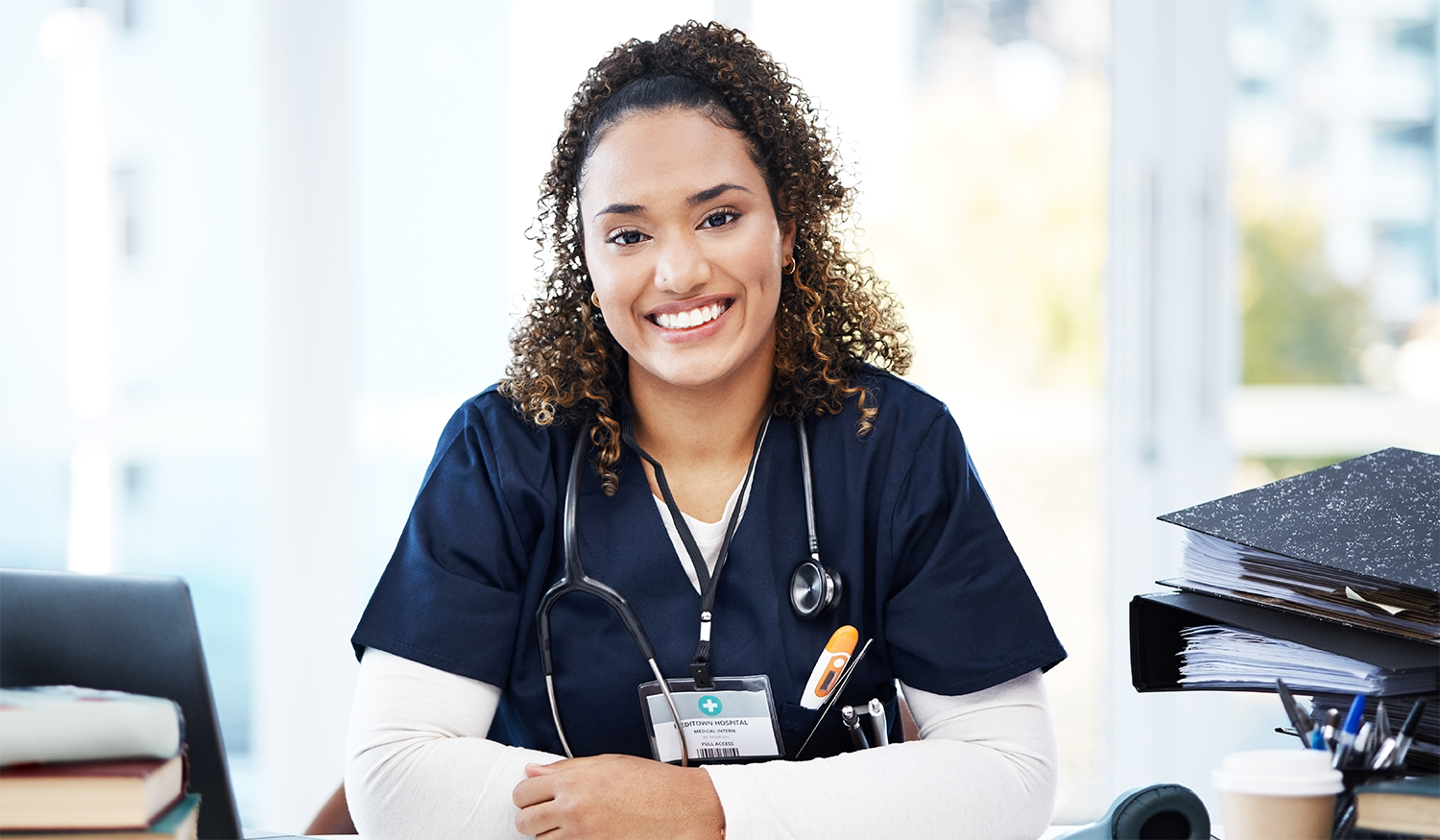 Mature female doctor discussing medical report with nurses in hospital hallway