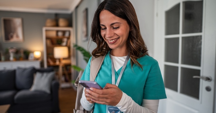Mature female doctor discussing medical report with nurses in hospital hallway