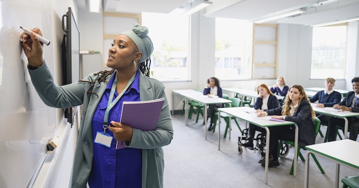 Mature female doctor discussing medical report with nurses in hospital hallway