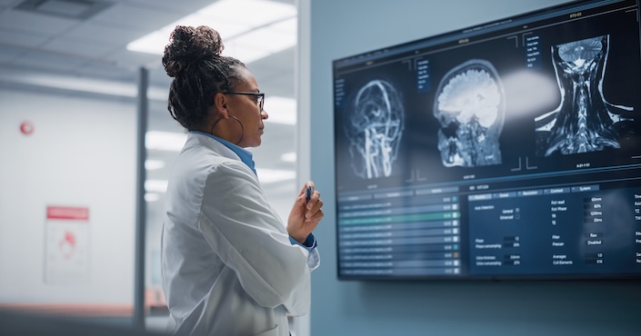 Mature female doctor discussing medical report with nurses in hospital hallway