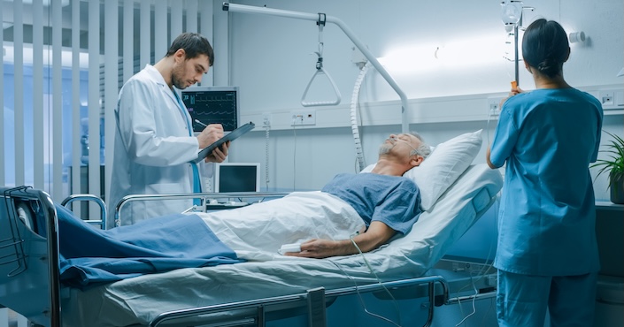 Mature female doctor discussing medical report with nurses in hospital hallway