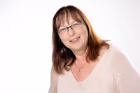 Porträt einer lächelnden Frau mit Brille vor weißem Hintergrund