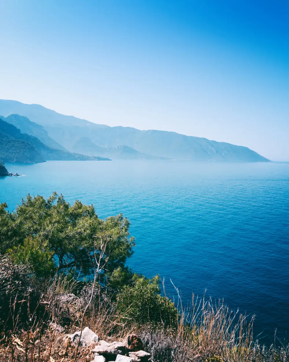 Küste mit grünen Hügeln und türkisem Meer