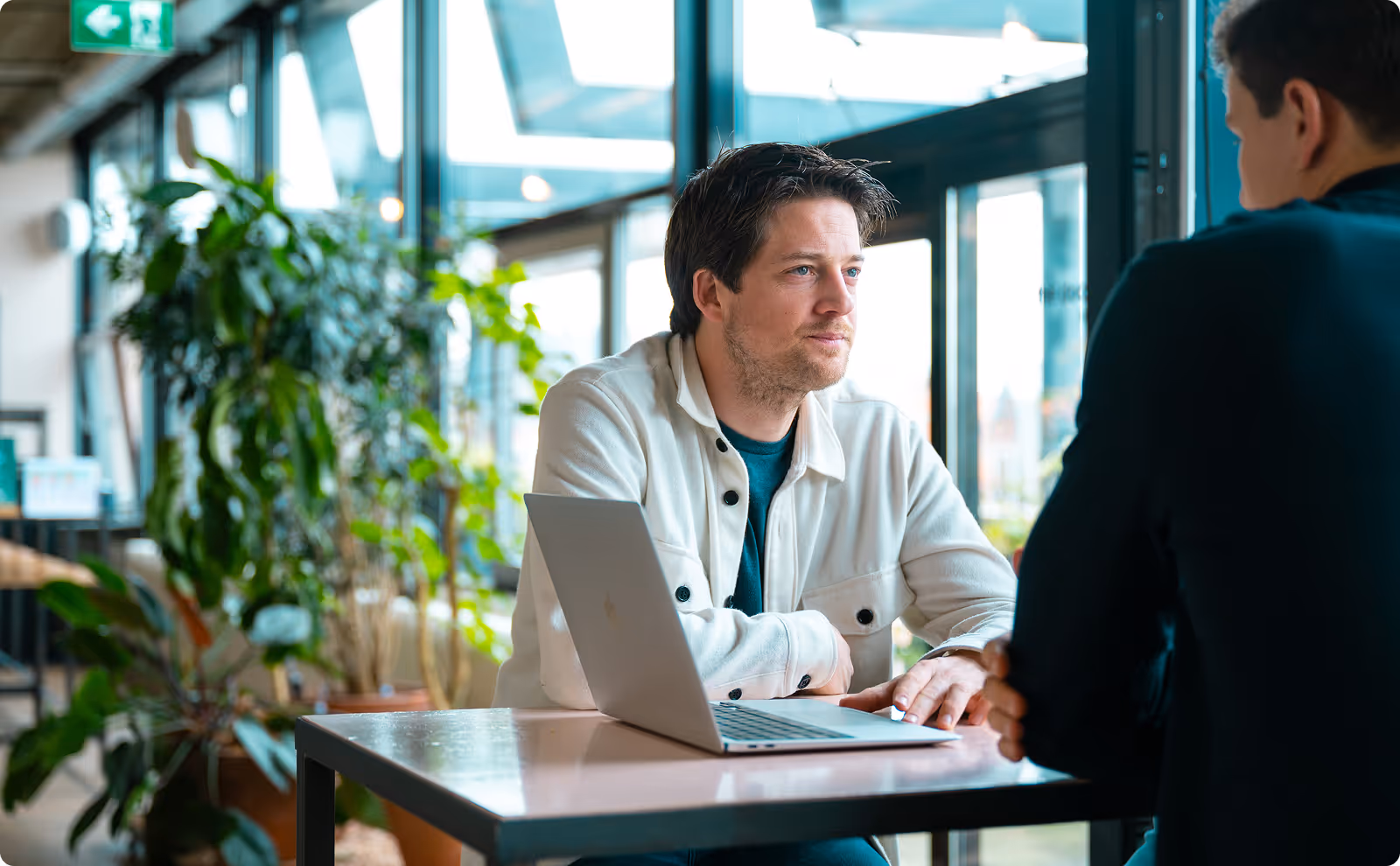 Ondernemer van Groeileaders in gesprek met laptop op tafel