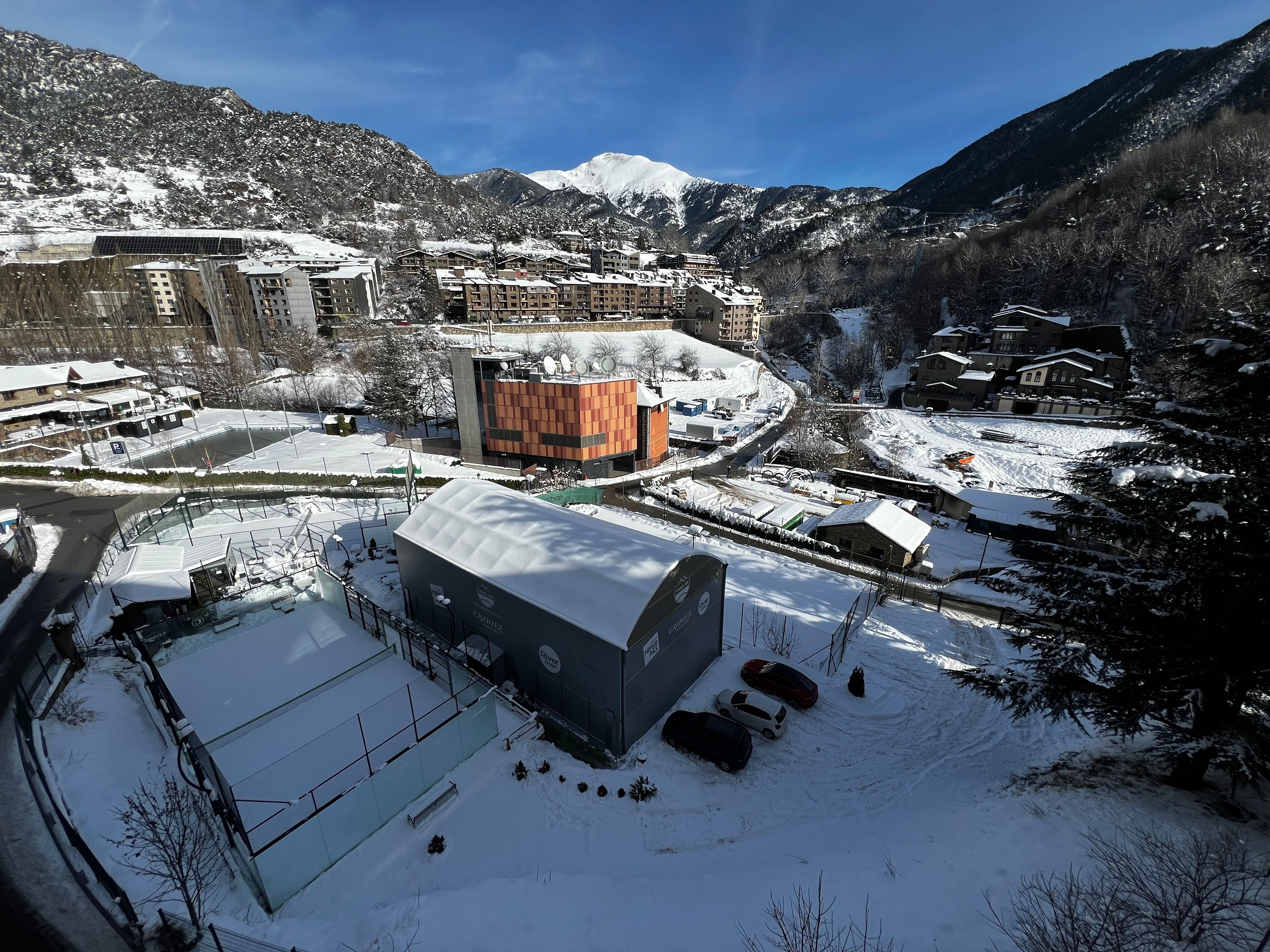 Aerial view of a snowy mountain town in Andorra during winter.