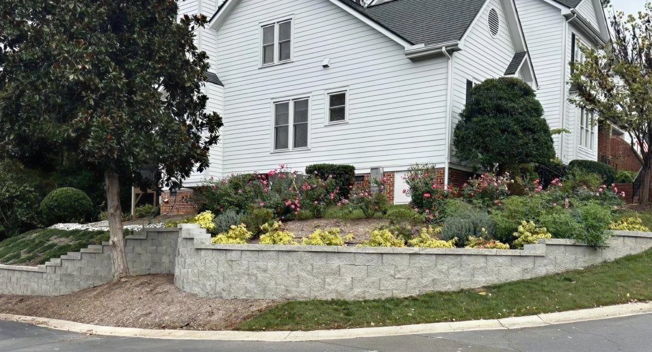 A house featuring a retaining wall and well-maintained landscaping, showcasing a blend of architecture and nature.