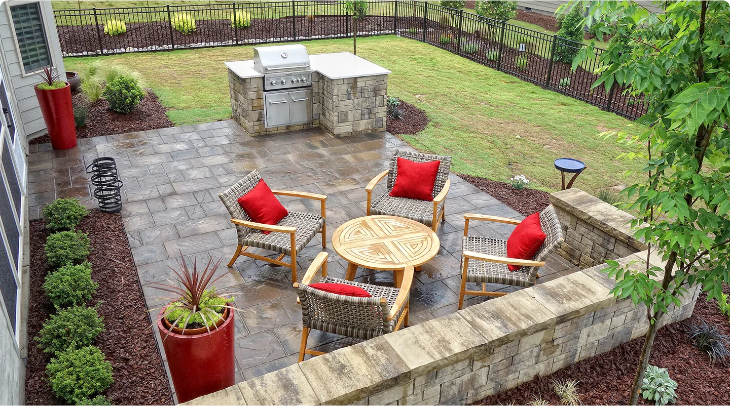 A patio featuring a grill and several chairs arranged for outdoor dining and relaxation.