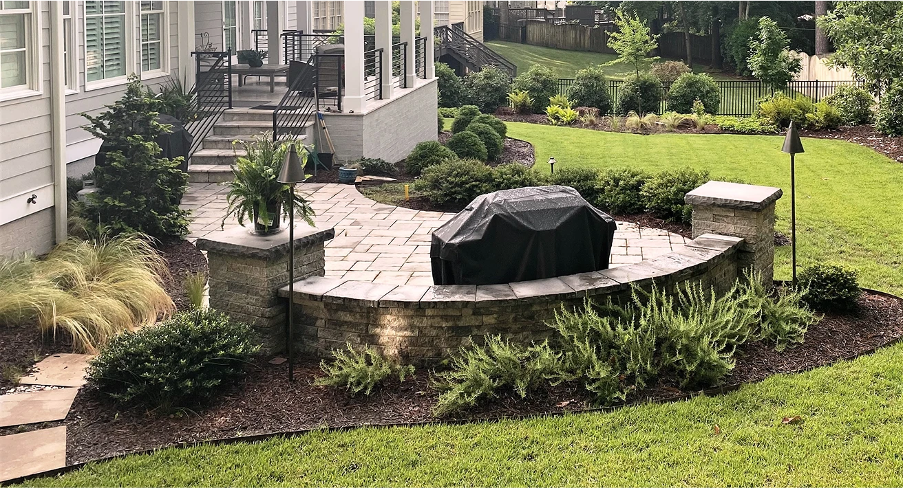A backyard featuring a grill and a cozy patio area, perfect for outdoor gatherings and relaxation.