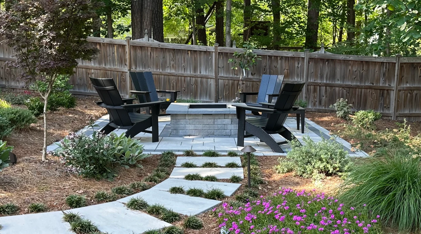 A patio set with two chairs and a table in front of a fence.