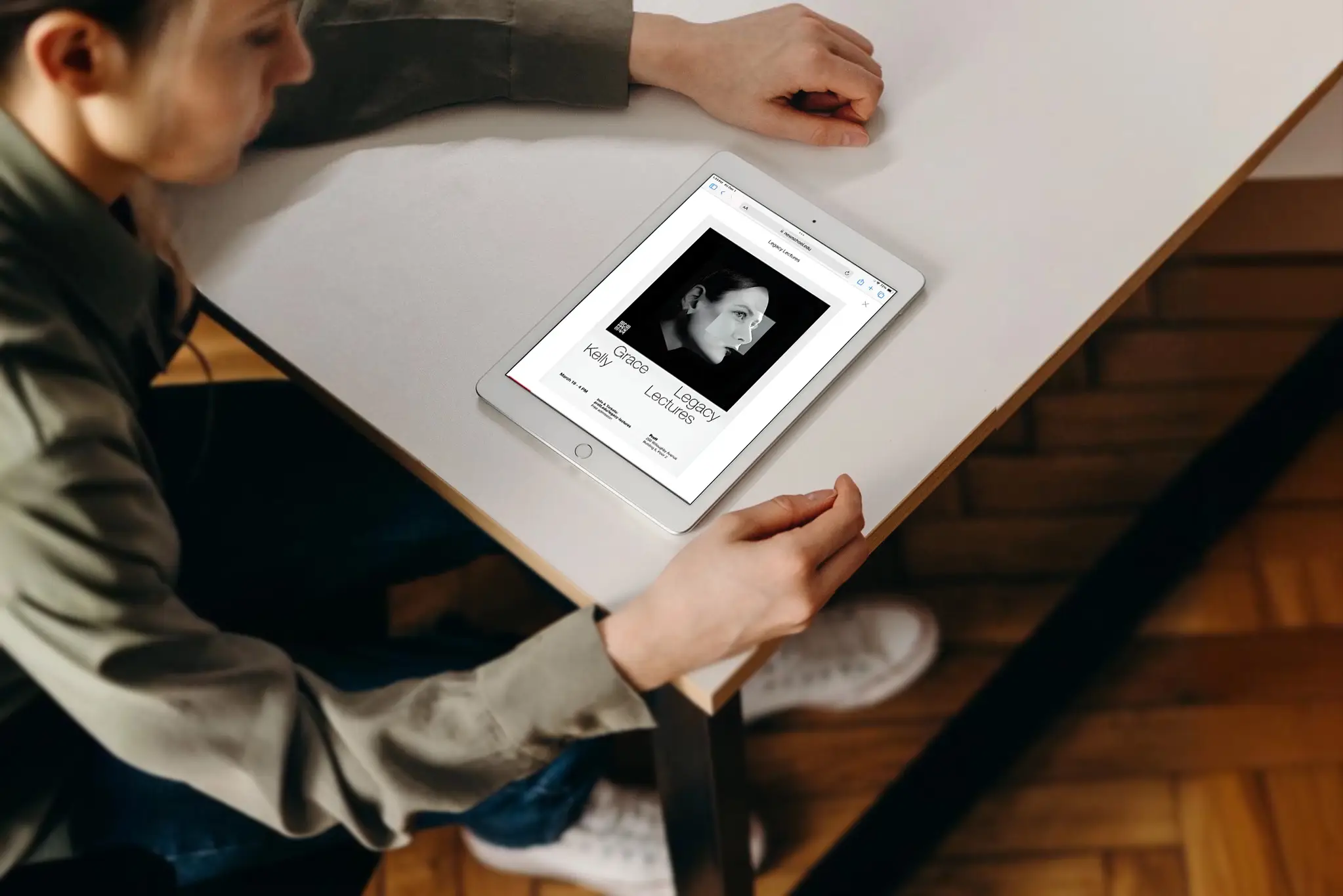 A woman gazing at an iPad featuring a school ad for the upcoming lecture