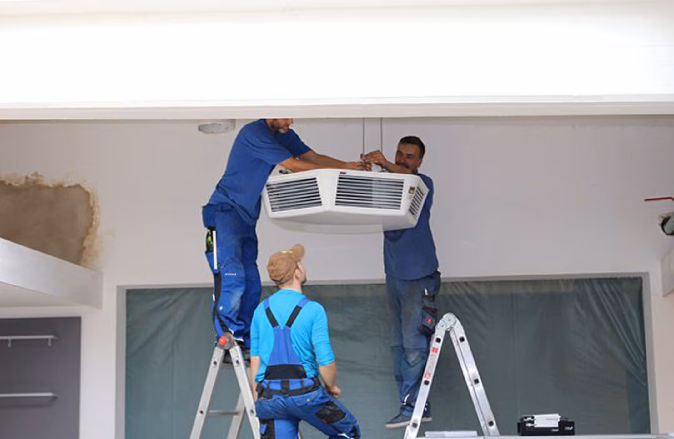 Mitarbeiter von Gast Installieren eine Klimaanlage in der Schule  