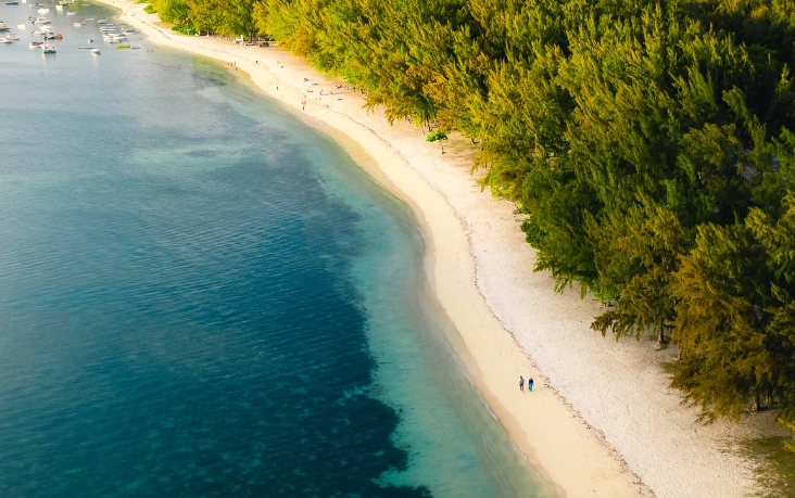 Eaux turquoise caressant une plage immaculée, invitation à la détente et à l’évasion avec MJ Holidays.
