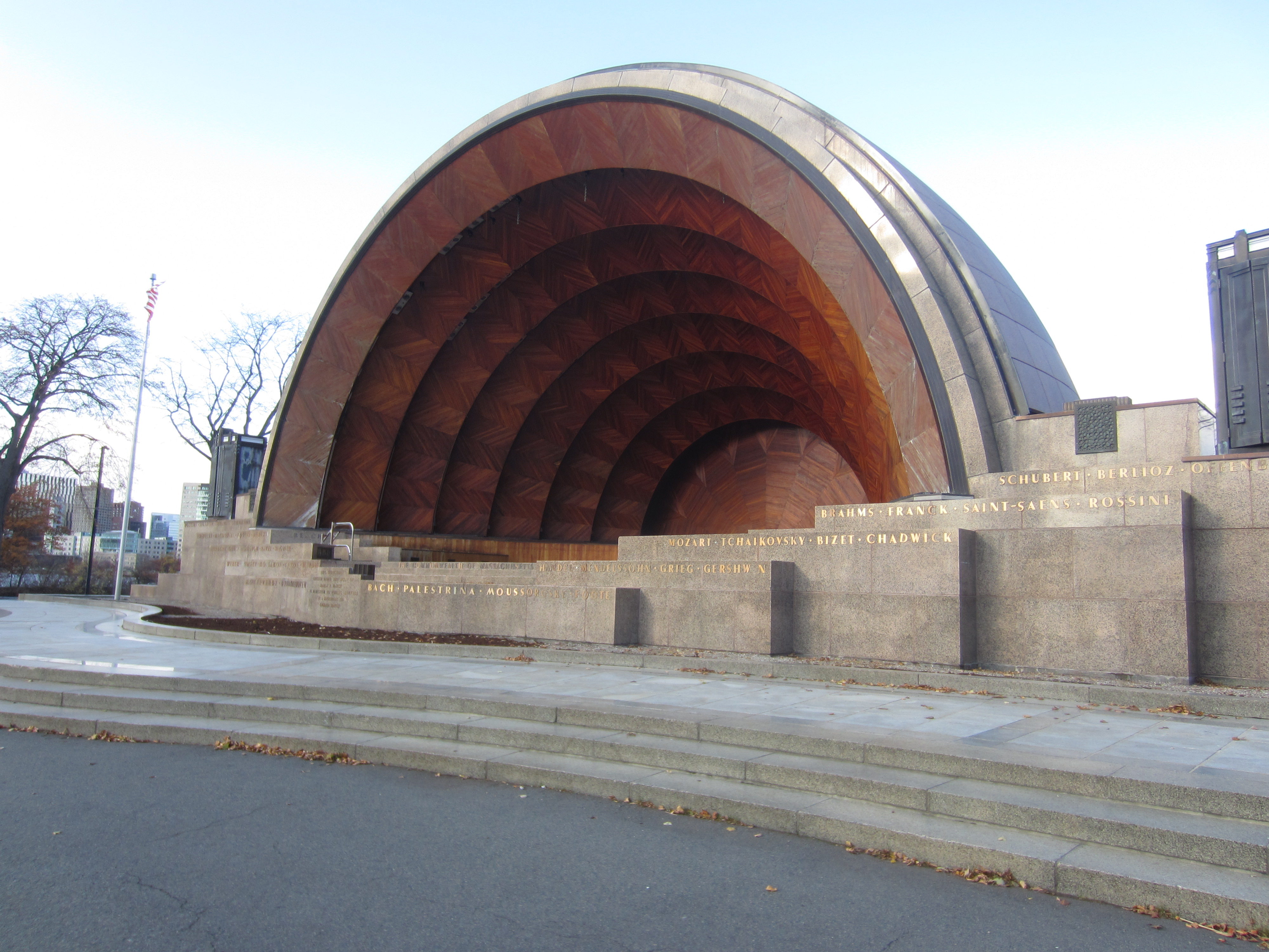this picture shows the hatch shell pavilion. it is a big wooden art deco amphitheater with names of significant performers inscribed in gold