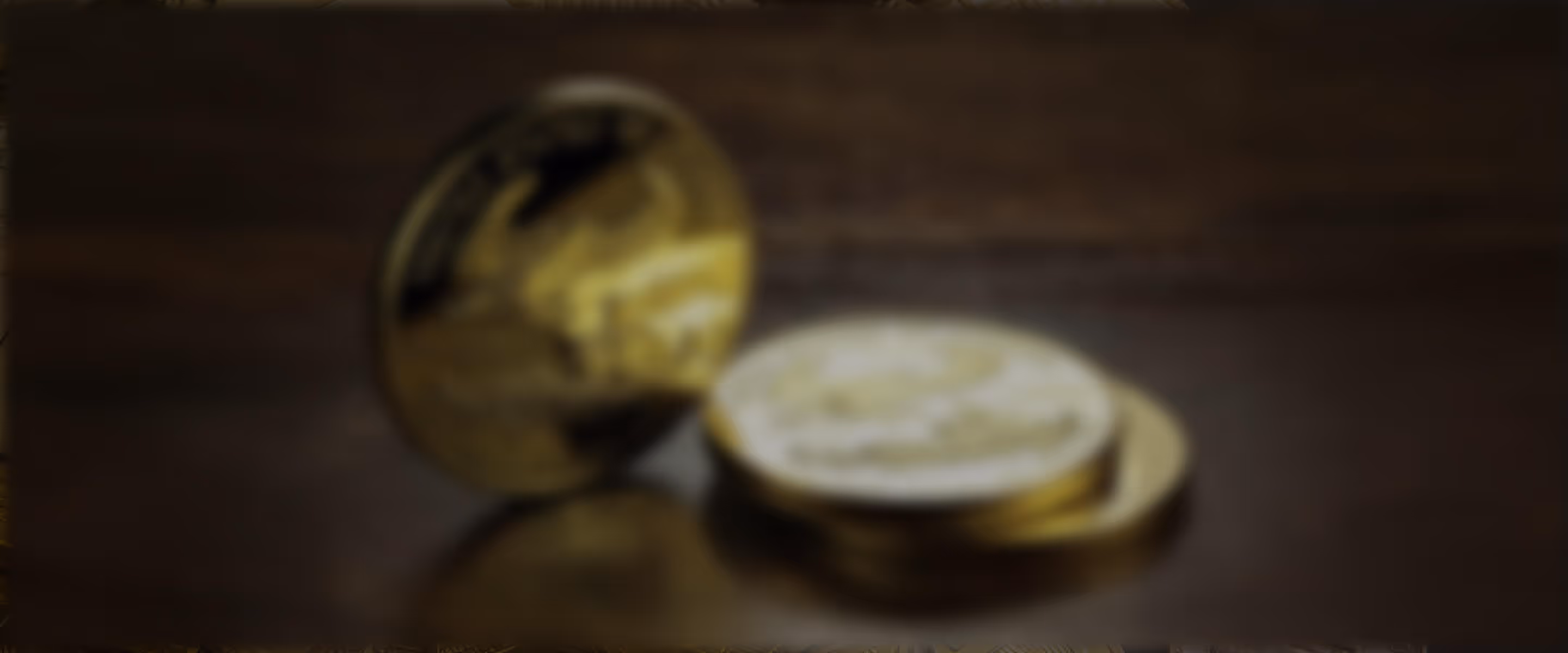 blurry Stack of American Gold Eagle coins on a wooden surface — United States of America 1 oz fine gold $50 coins
