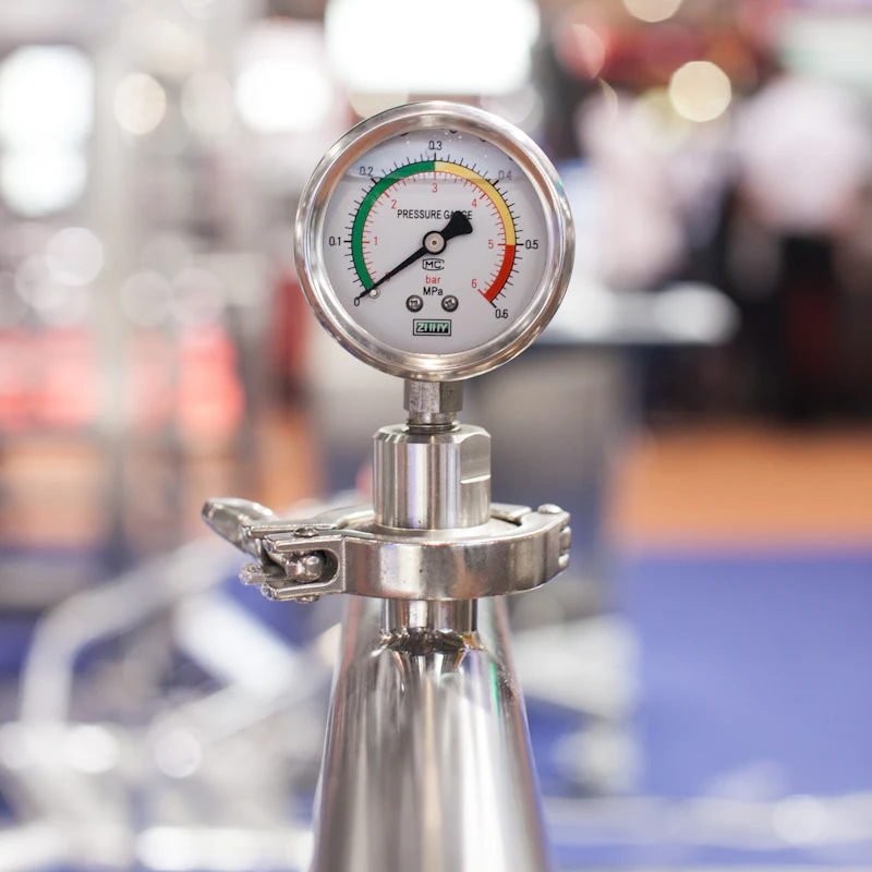 Pressure gauge with green, yellow, and red zones on a stainless steel fitting