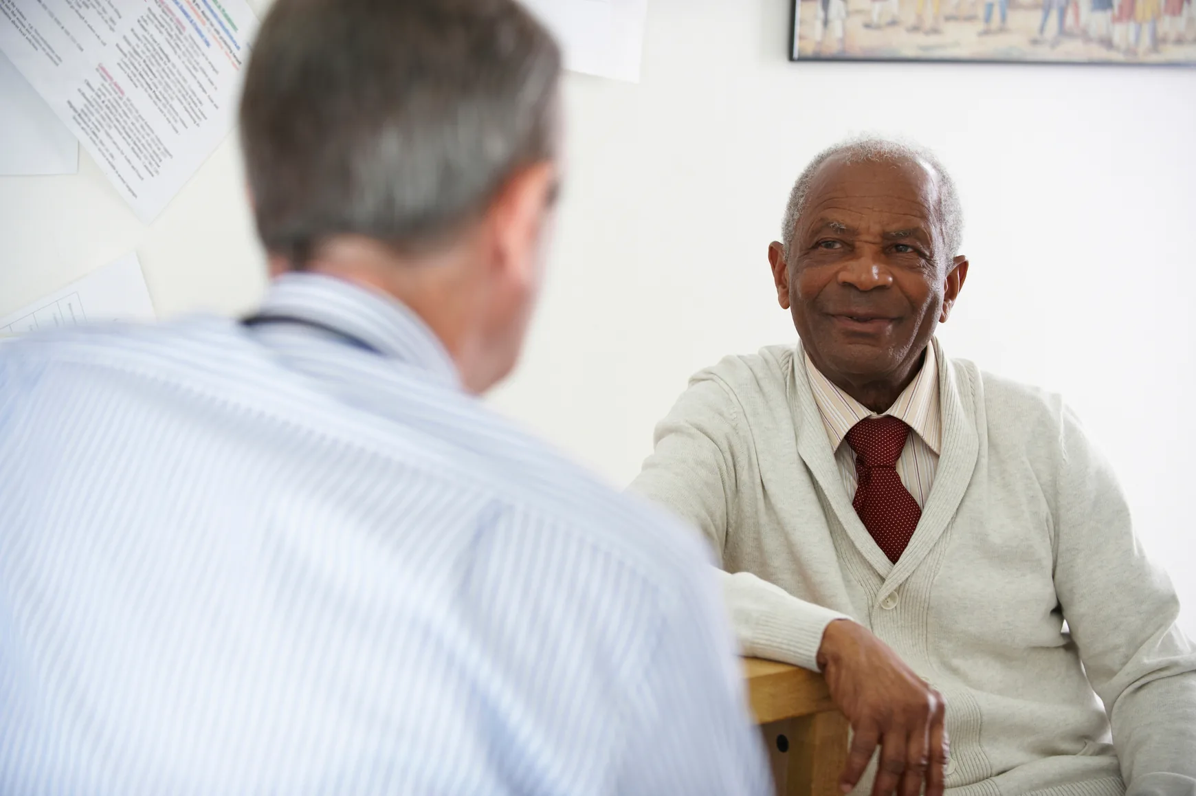 A senior man talking with a member of the care team indoors