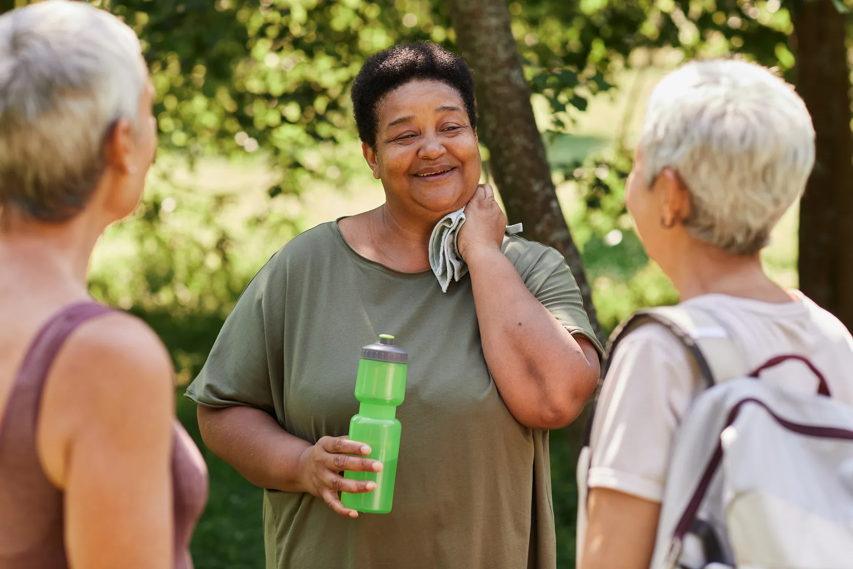 Two women talking and laughing together outdoors on a sunny day