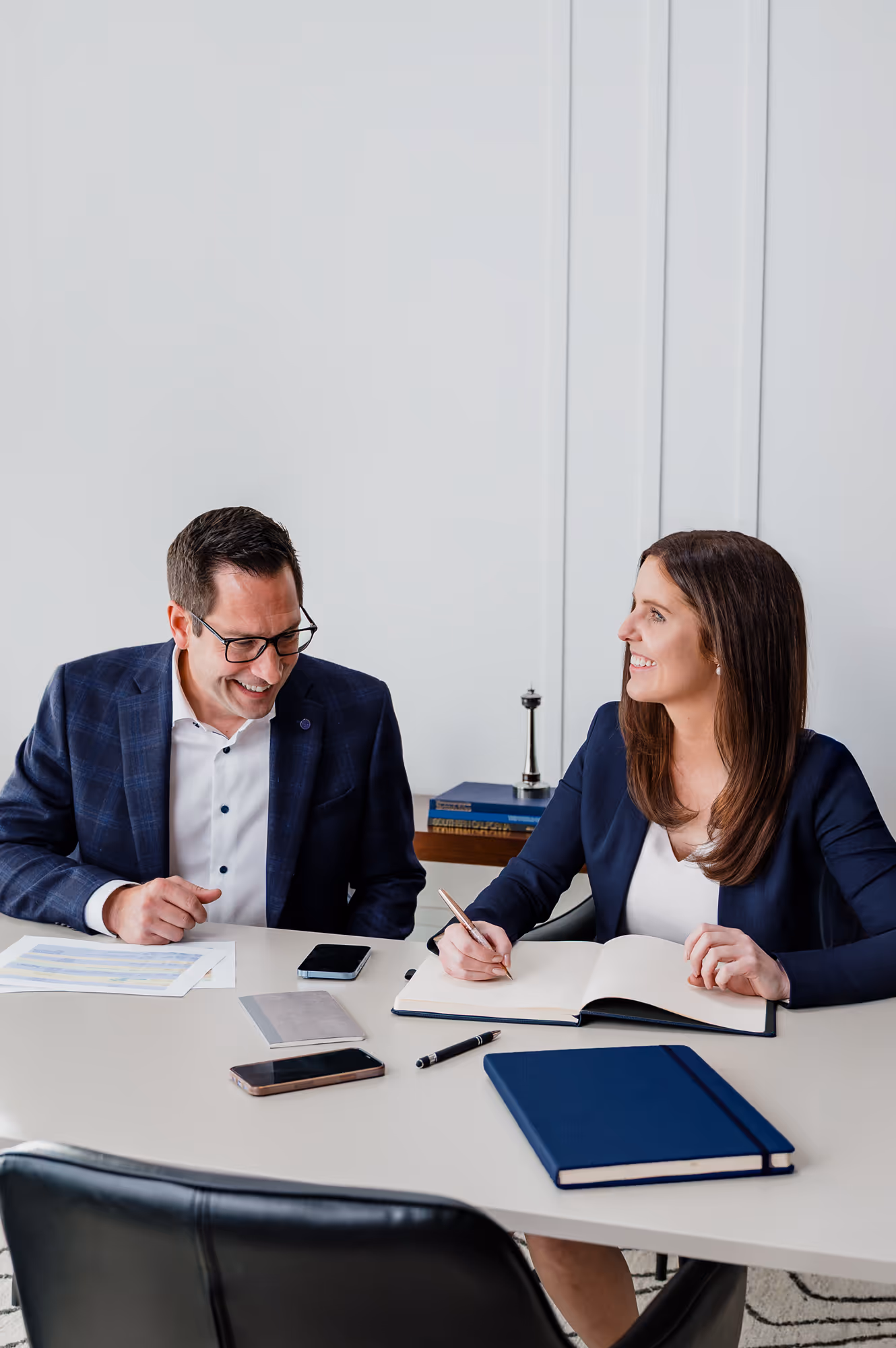 Diamond WIllow partners, Grant Daunheimer & Haley Talbot engaged in a business discussion at an office desk.
