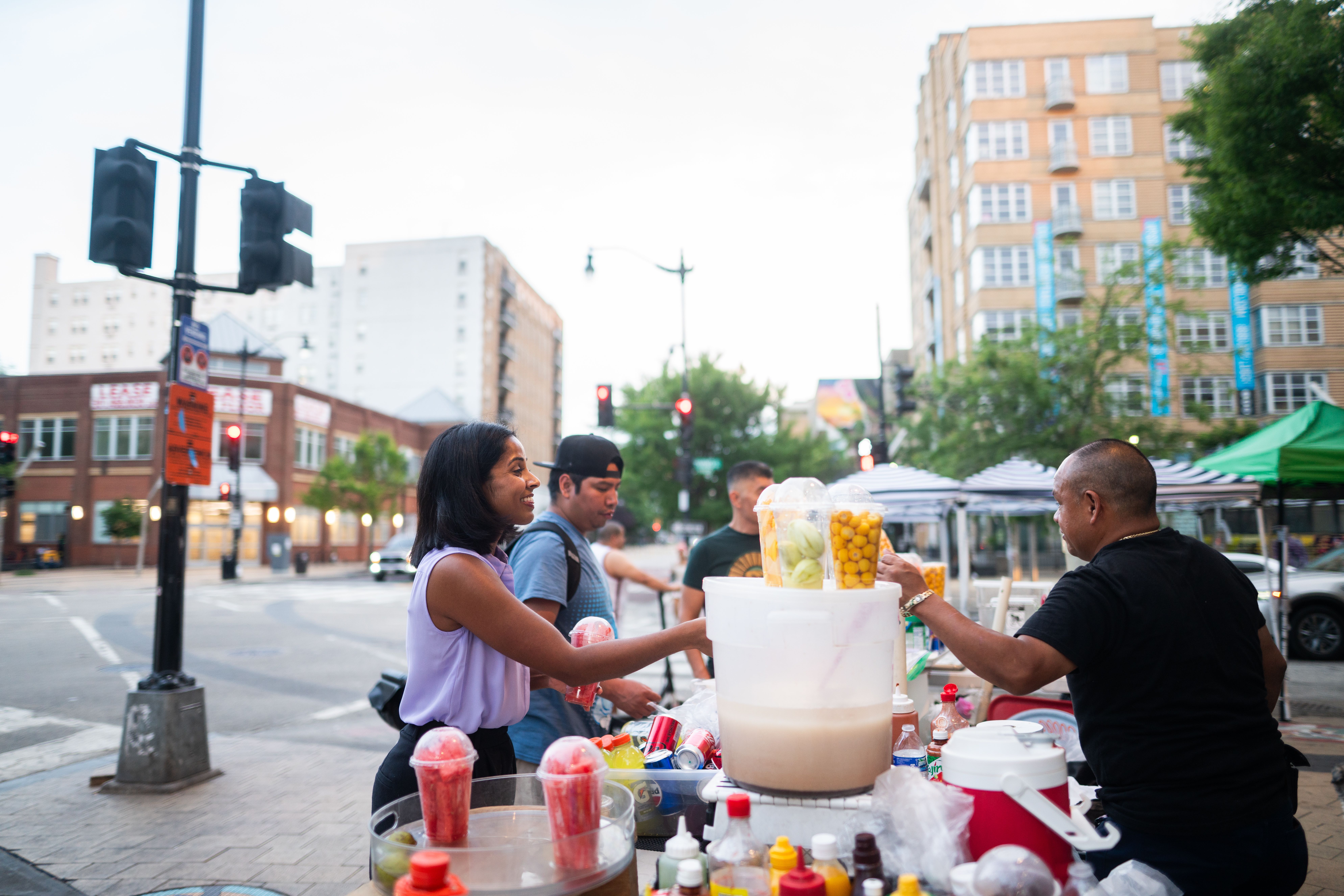 Photo of Aparna buying some fruit from one of the street vendors in Columbia Heights