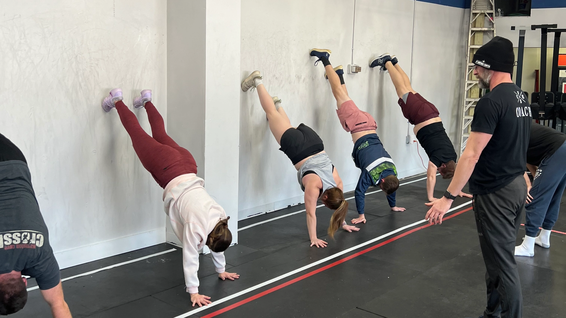 A group of individuals performing push-ups in a gym during a Nutrition Coaching session at CrossFit Empire South, Huntsville, AL.