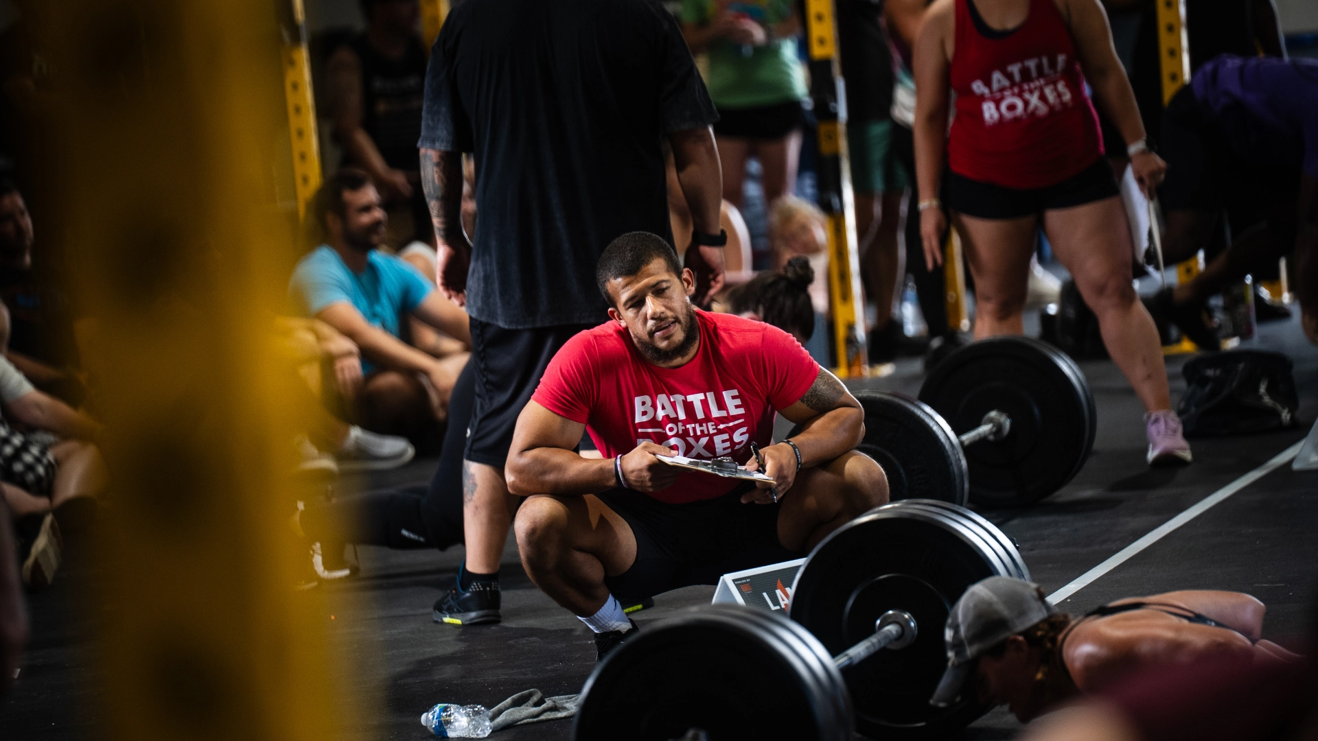 A man squats with a barbell in a gym, showcasing personal training at CrossFit Empire South in Huntsville, AL.
