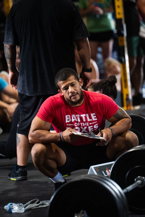 A man squats with a barbell in a gym, showcasing personal training at CrossFit Empire South in Huntsville, AL.